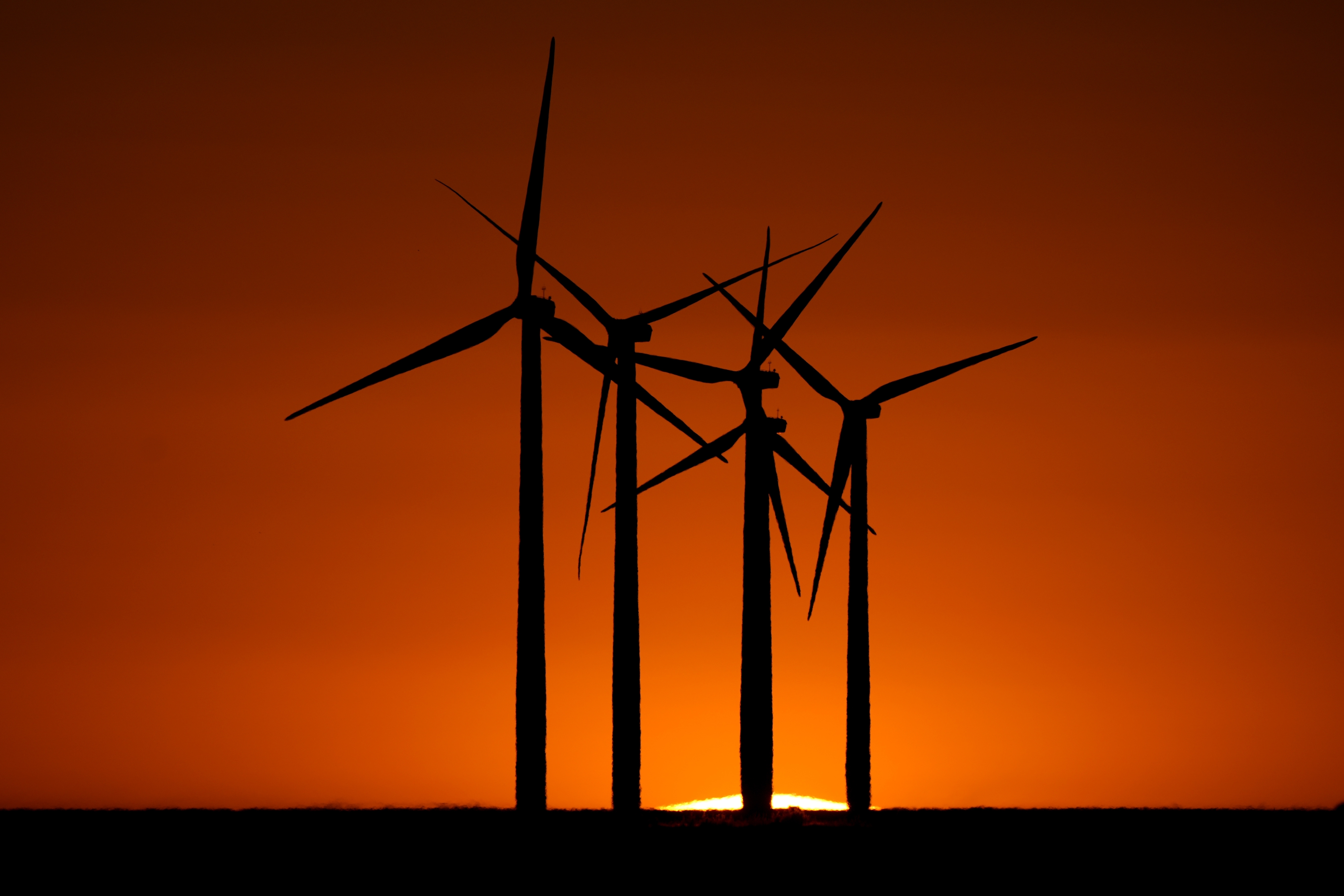 Wind turbines are silhouetted against the setting sun at the Spearville Wind Farm, Sunday, Sept. 29, 2024, near Spearville, Kan. (AP Photo/Charlie Riedel)