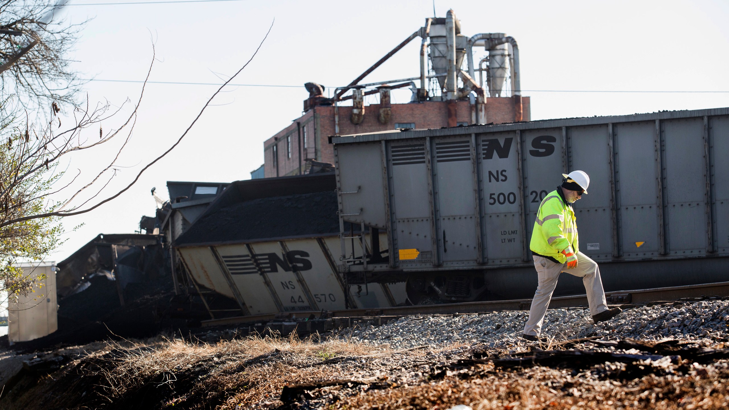 FILE - A Norfolk Southern worker walks next to the scene of a multi-car coal train derailment near Suffolk, Va., on Feb. 4, 2017. (Bill Tiernan/The Virginian-Pilot via AP, File)