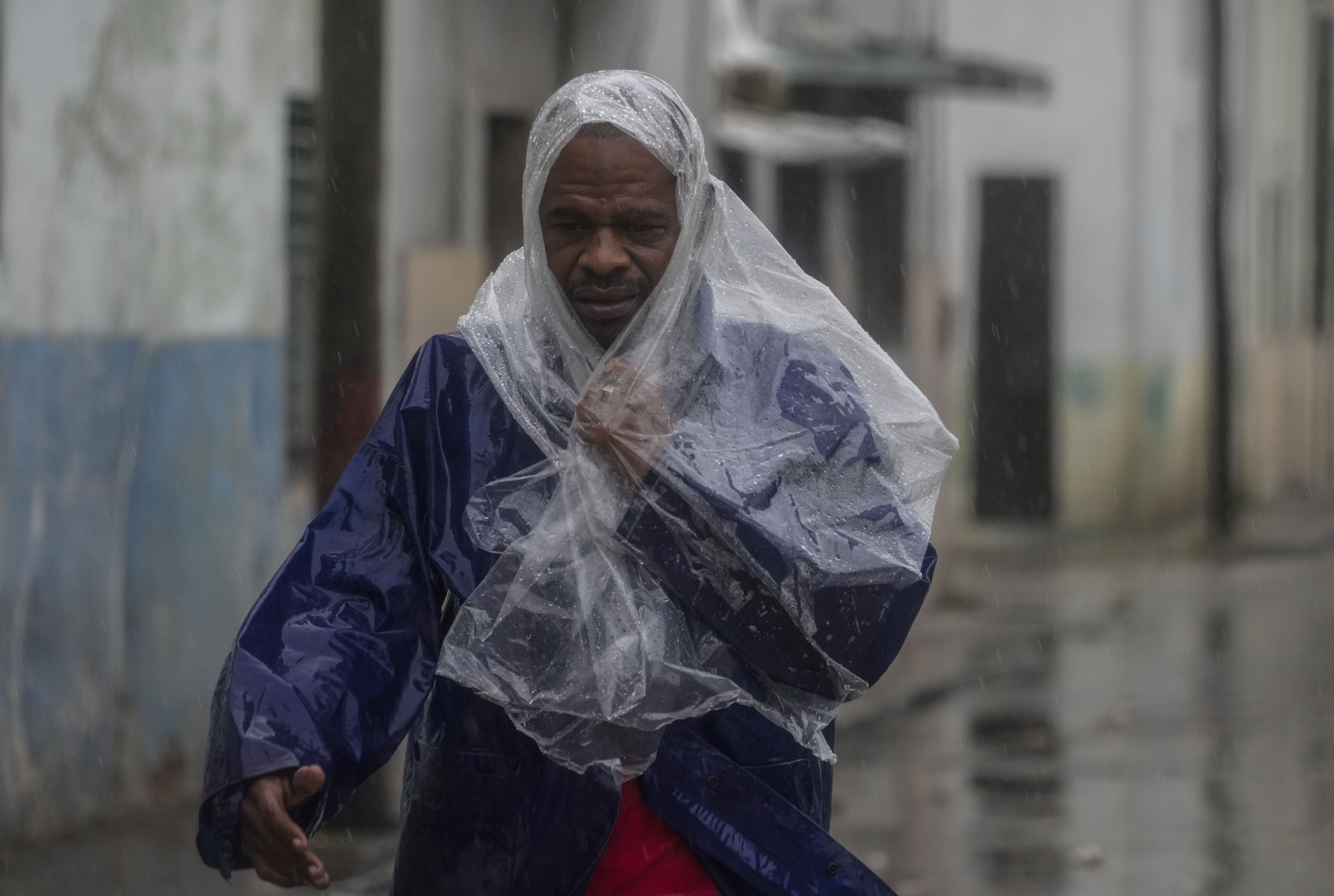 A man walks through the wind and rain brought by Hurricane Rafael in Havana, Cuba, Wednesday, Nov. 6, 2024. (AP Photo/Ramon Espinosa)