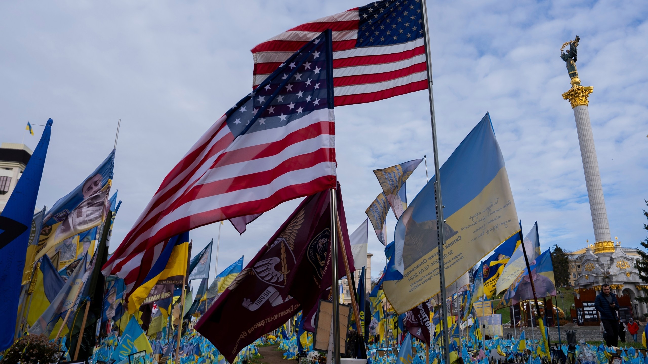 American and Ukrainian flags placed in honour of fallen servicemen flutter in the wind in front of statue in central square, in Kyiv, Ukraine, Tuesday, Nov. 5, 2024. (AP Photo/Alex Babenko)