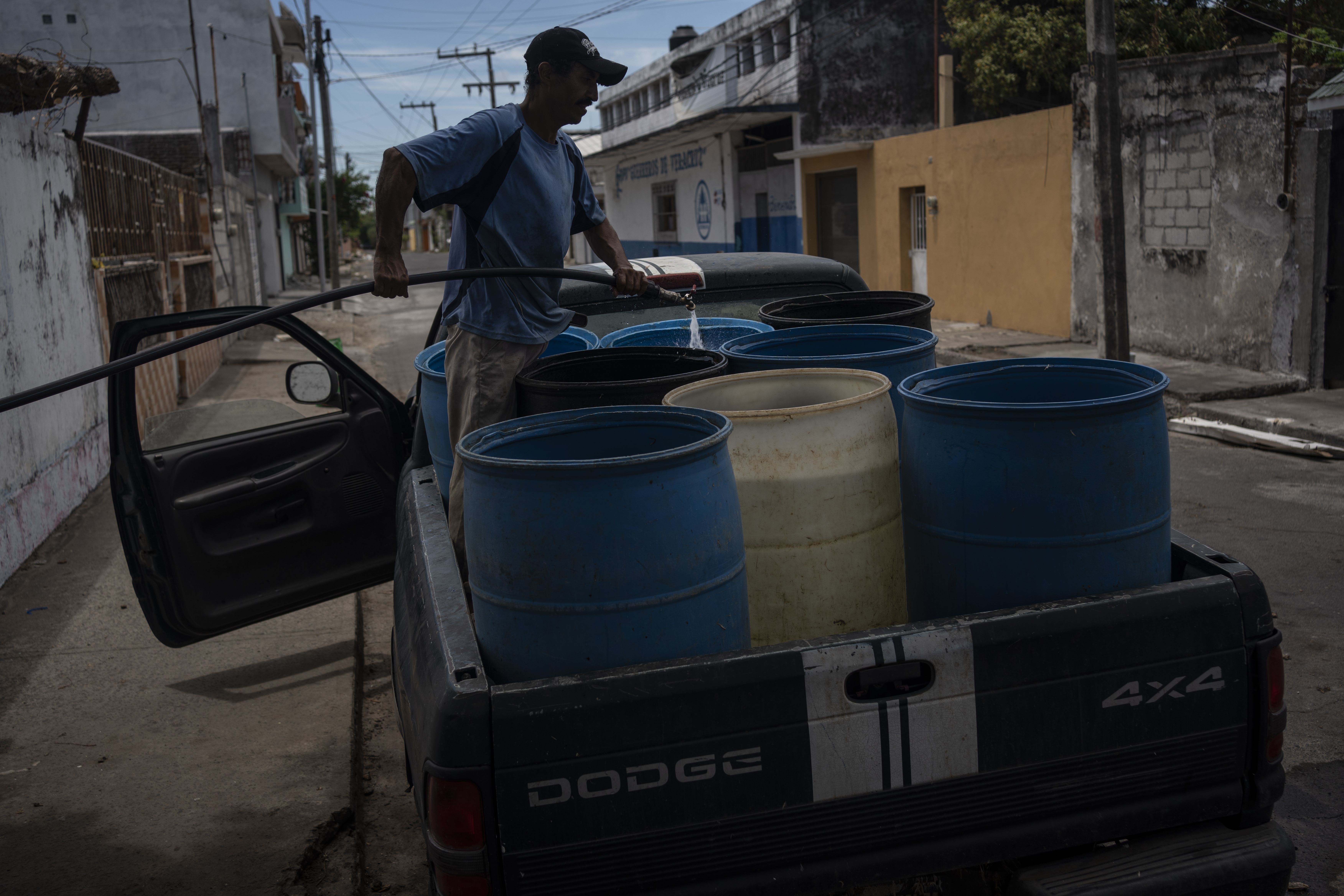 FILE - A man fills containers with water due to the shortage caused by high temperatures and drought in Veracruz, Mexico, on June 16, 2024. (AP Photo/Felix Marquez, File)