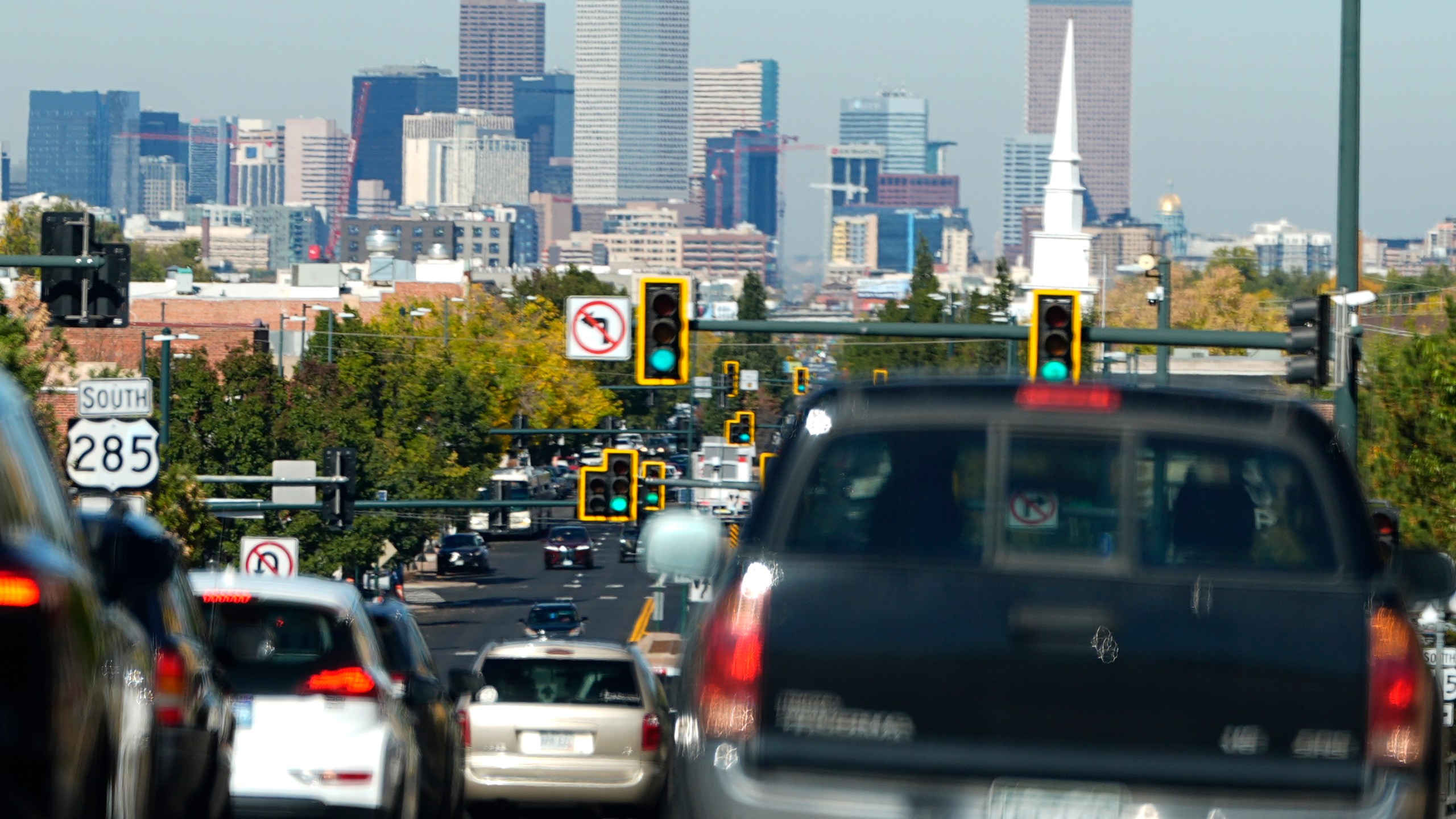 FILE - Heavy traffic moves northbound along South Broadway at Hampden Avenue as the Denver city skyline hangs in the background, Oct. 23, 2024, in Englewood, Colo. (AP Photo/David Zalubowski)