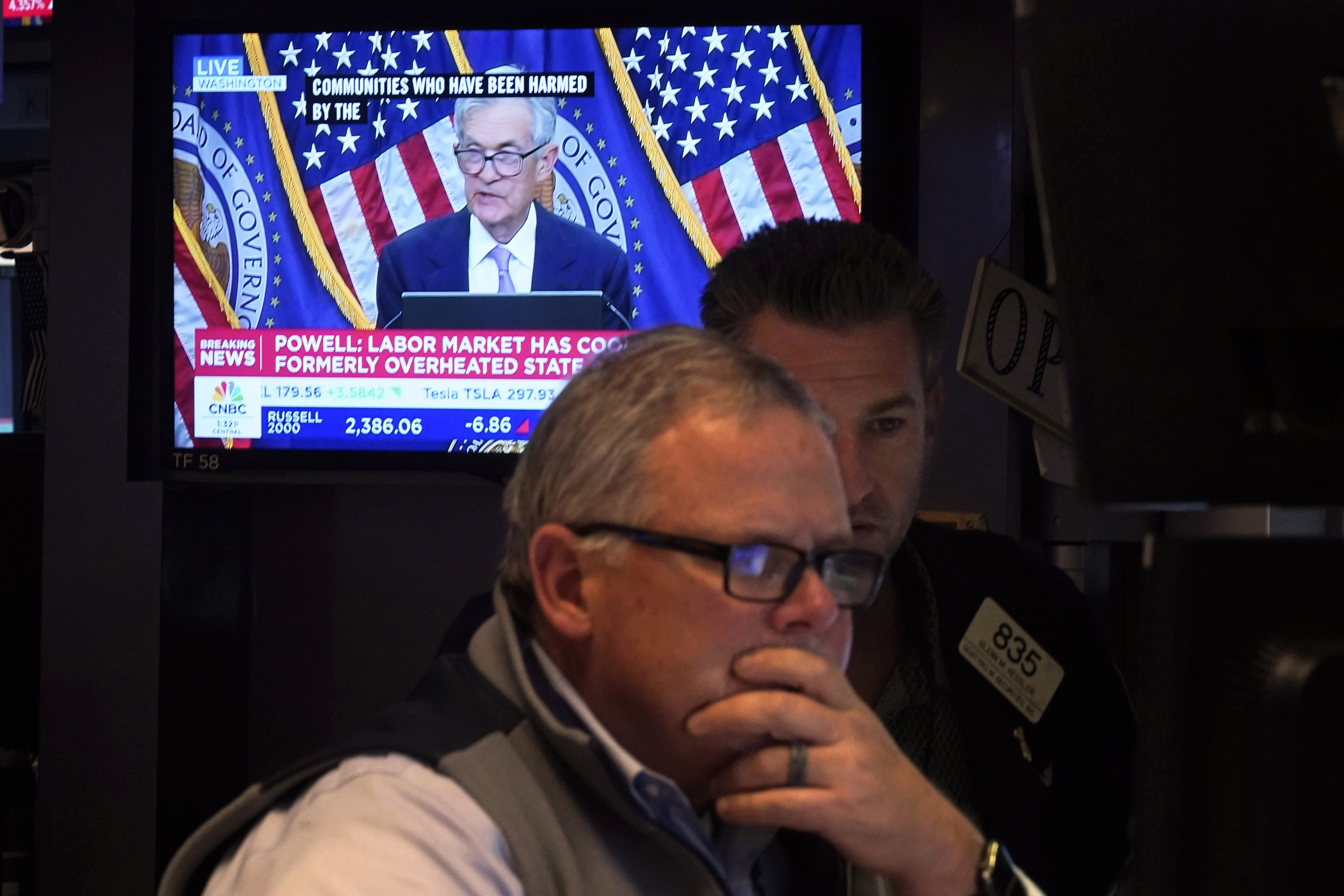 A pair of traders work on the floor of the New York Stock Exchange, Thursday, Nov. 7, 2024, in New York, as Federal Reserve Chair Jerome Powell news conference in Washington is displayed on a monitor. (AP Photo/Richard Drew)