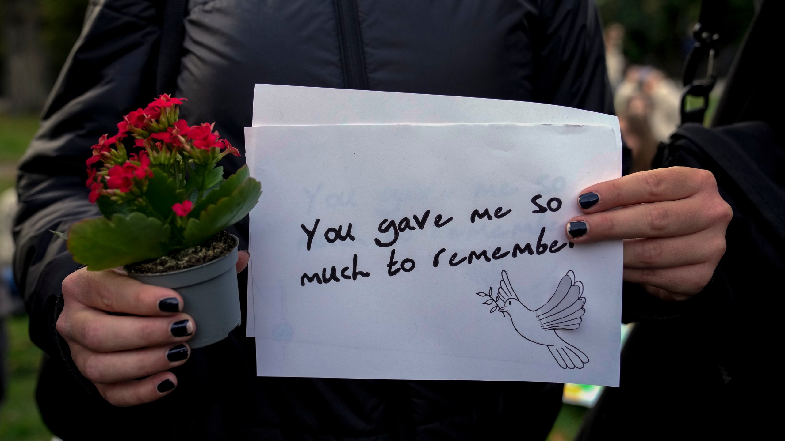 A fan holds a message as fans gather to pay tribute to late British singer Liam Payne, former member of the British pop band One Direction in Treptower Park in Berlin, Germany, Sunday, Oct. 20, 2024. (AP Photo/Ebrahim Noroozi)