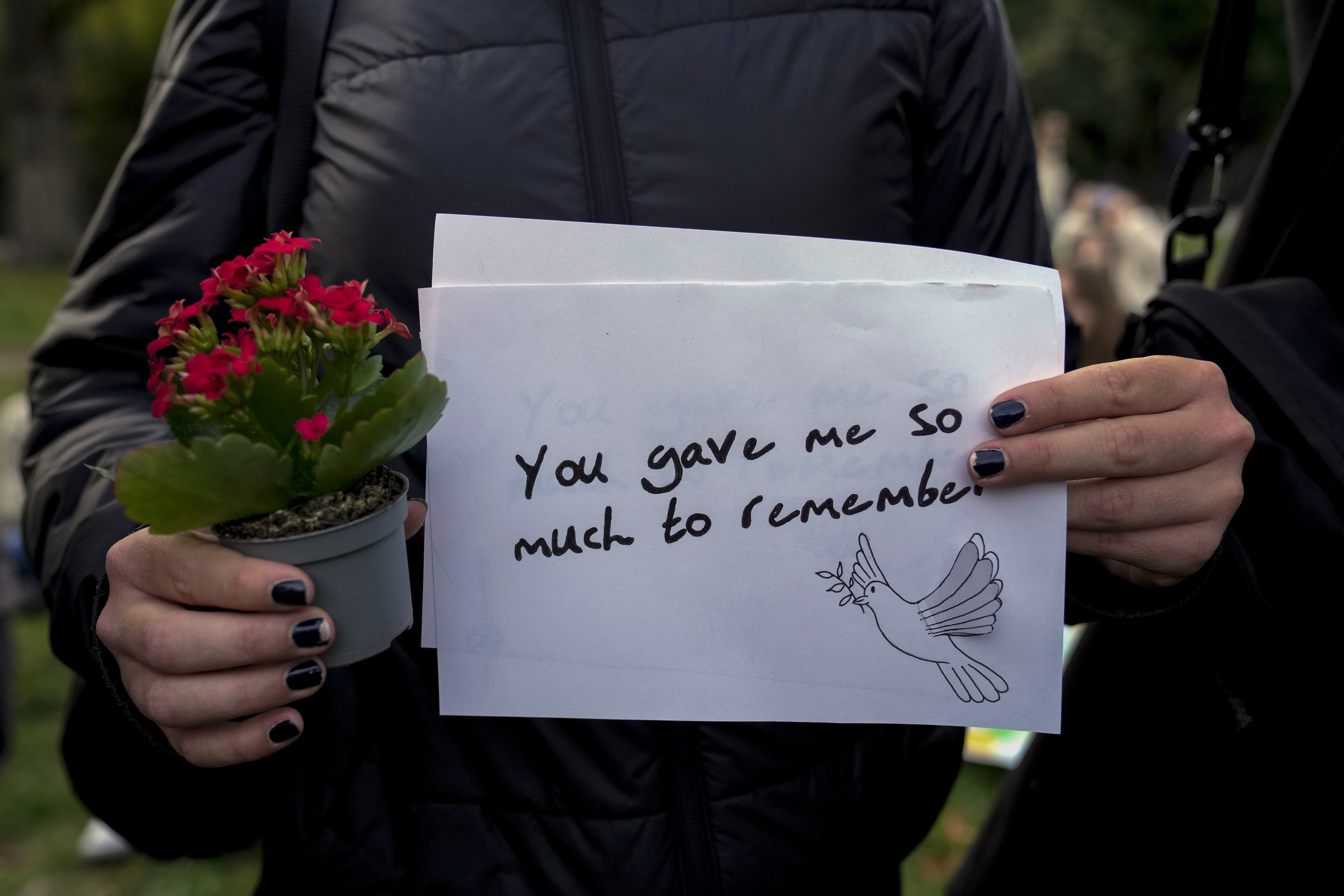 A fan holds a message as fans gather to pay tribute to late British singer Liam Payne, former member of the British pop band One Direction in Treptower Park in Berlin, Germany, Sunday, Oct. 20, 2024. (AP Photo/Ebrahim Noroozi)