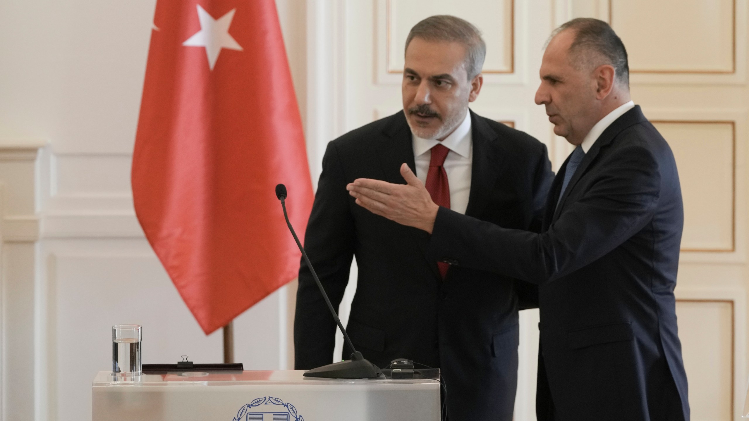 Greek Foreign Minister George Gerapetritis, right shows the way to his Turkish counterpart Hakan Fidan after the end of their news conference, in Athens, Greece, Friday, Nov. 8, 2024. (AP Photo/Thanassis Stavrakis)