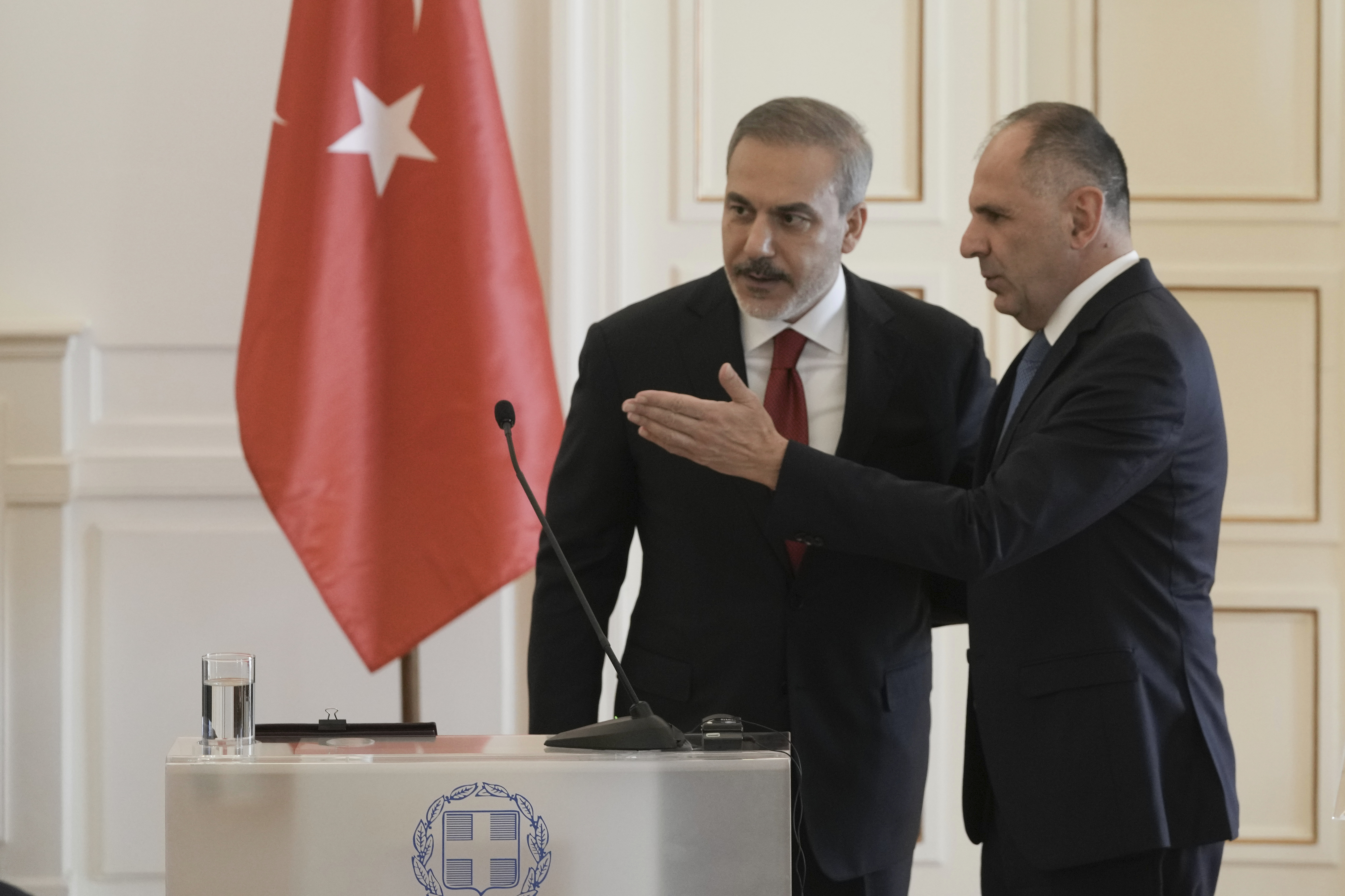 Greek Foreign Minister George Gerapetritis, right shows the way to his Turkish counterpart Hakan Fidan after the end of their news conference, in Athens, Greece, Friday, Nov. 8, 2024. (AP Photo/Thanassis Stavrakis)