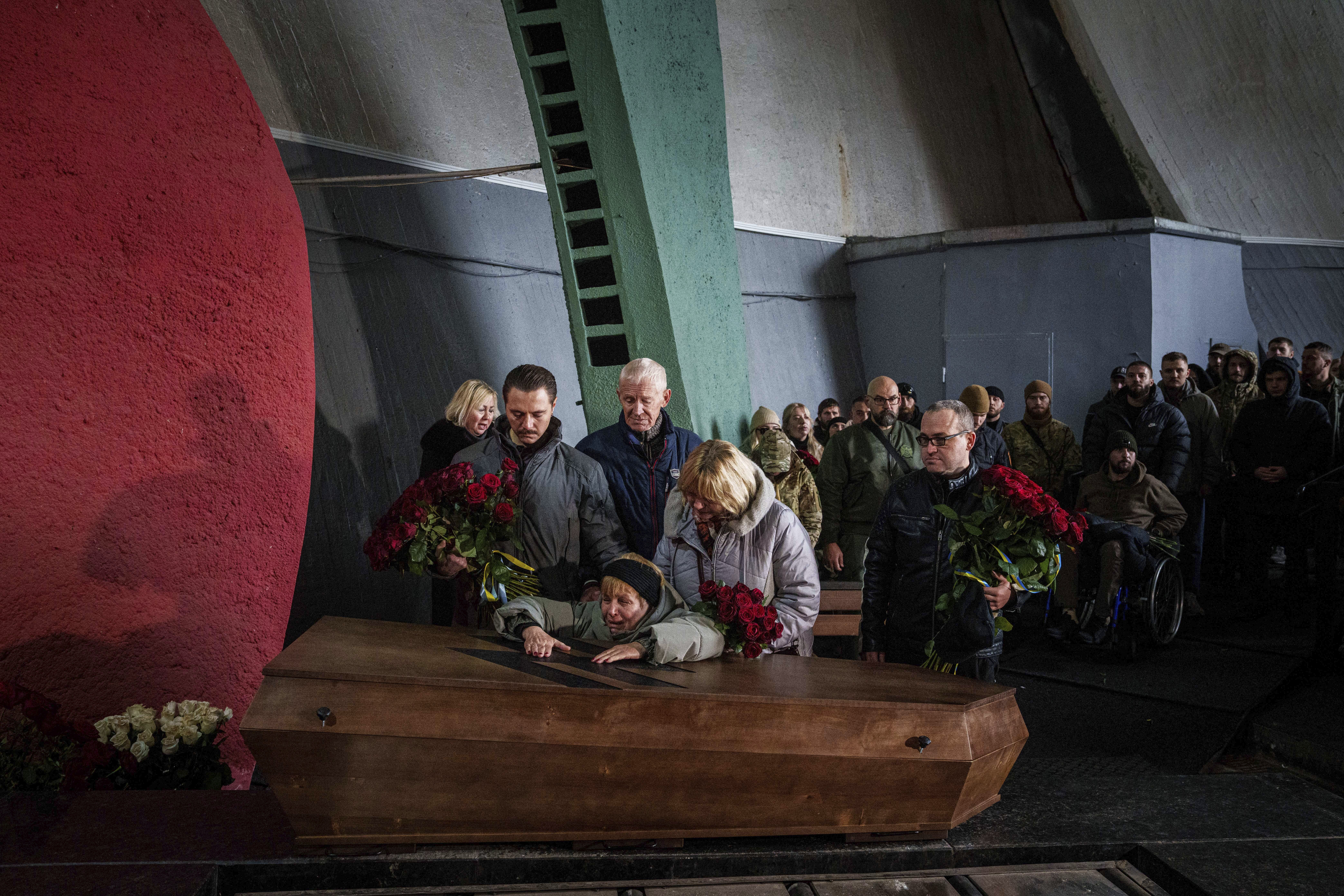 The mother cries over the coffin of her daughter Valentyna Nagorna aka "Valkiria", Ukrainian military medic of 3rd assault brigade who was killed together with his boyfriend Danylo Liashkevych aka "Berserk, during the funeral ceremony at crematorium in Kyiv, Ukraine, Friday, Nov. 8, 2024. (AP Photo/Evgeniy Maloletka)