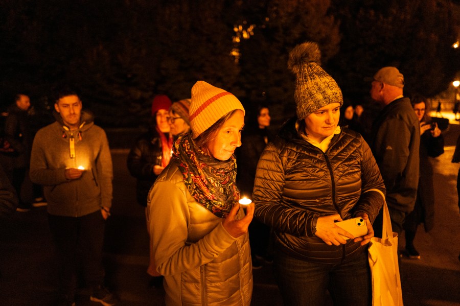 Friends hold candles while remembering Mackenzie Michalski, an 31-year-old American tourist who was murdered while on vacation, during a candlelight vigil in Budapest, Hungary, Saturday, Nov. 9, 2024. (AP Photo/Bela Szandelszky)