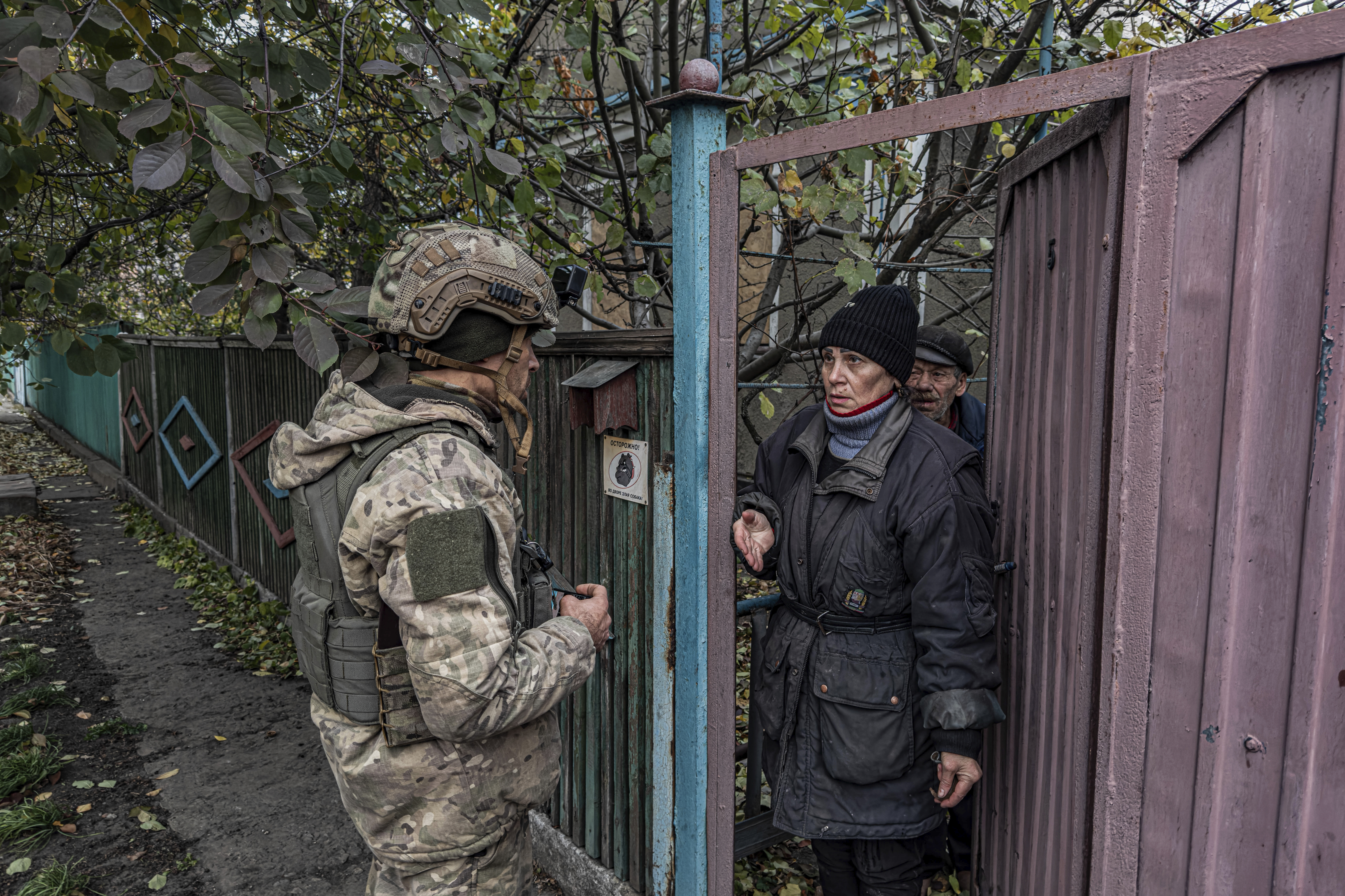 Pipa Vasyl, a policeman of the "White Angels", tries to convince a local woman to evacuate from Kurakhove, Donetsk region, Ukraine, on Nov. 7, 2024. (AP Photo/Anton Shtuka)