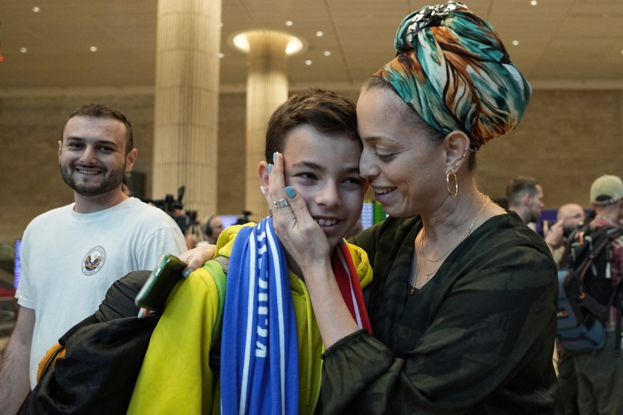 A woman embraces her son, who is a fan of Maccabi Tel Aviv, as he arrives at Israel's Ben-Gurion International Airport on a flight from Amsterdam, where Israeli soccer fans were attacked following a match between the Israeli club and Ajax Amsterdam in Lod, Israel, Friday, Nov. 8, 2024. (AP Photo/Tsafrir Abayov)