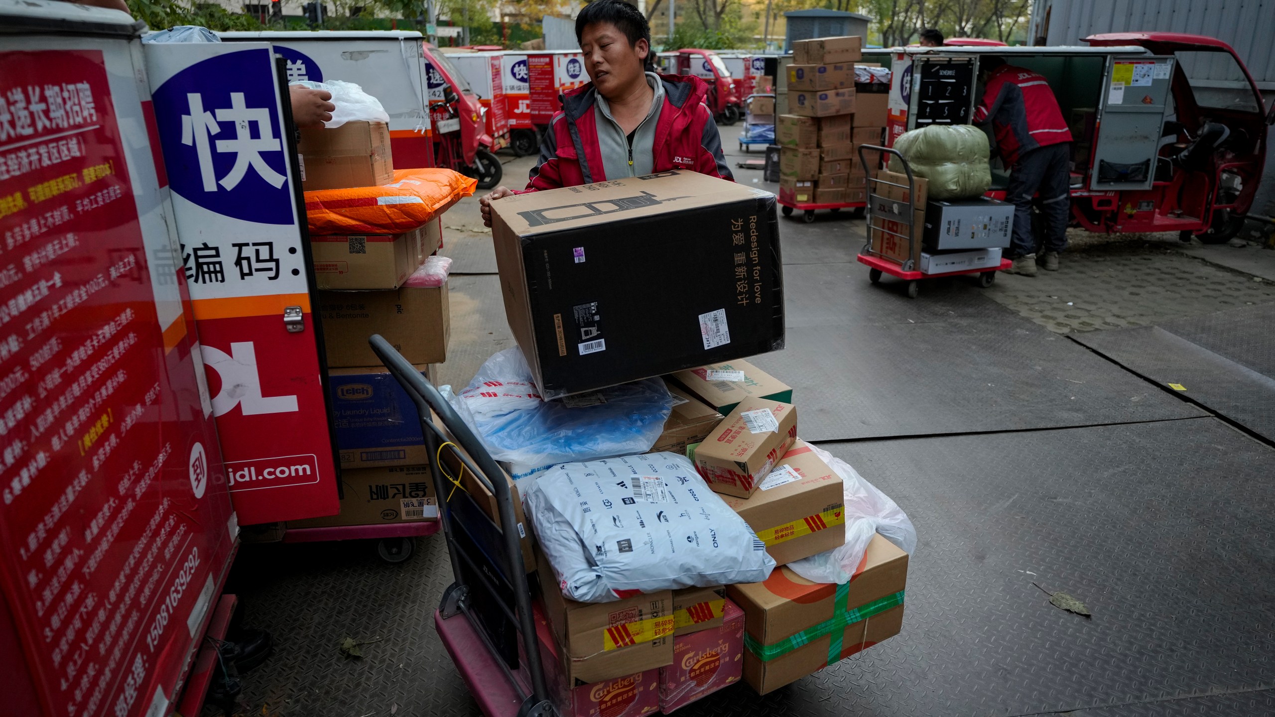 Delivery couriers sort out parcels for their customers at a distribution center for e-commerce platform JD.com in Beijing, Monday, Nov. 11, 2024. (AP Photo/Andy Wong)