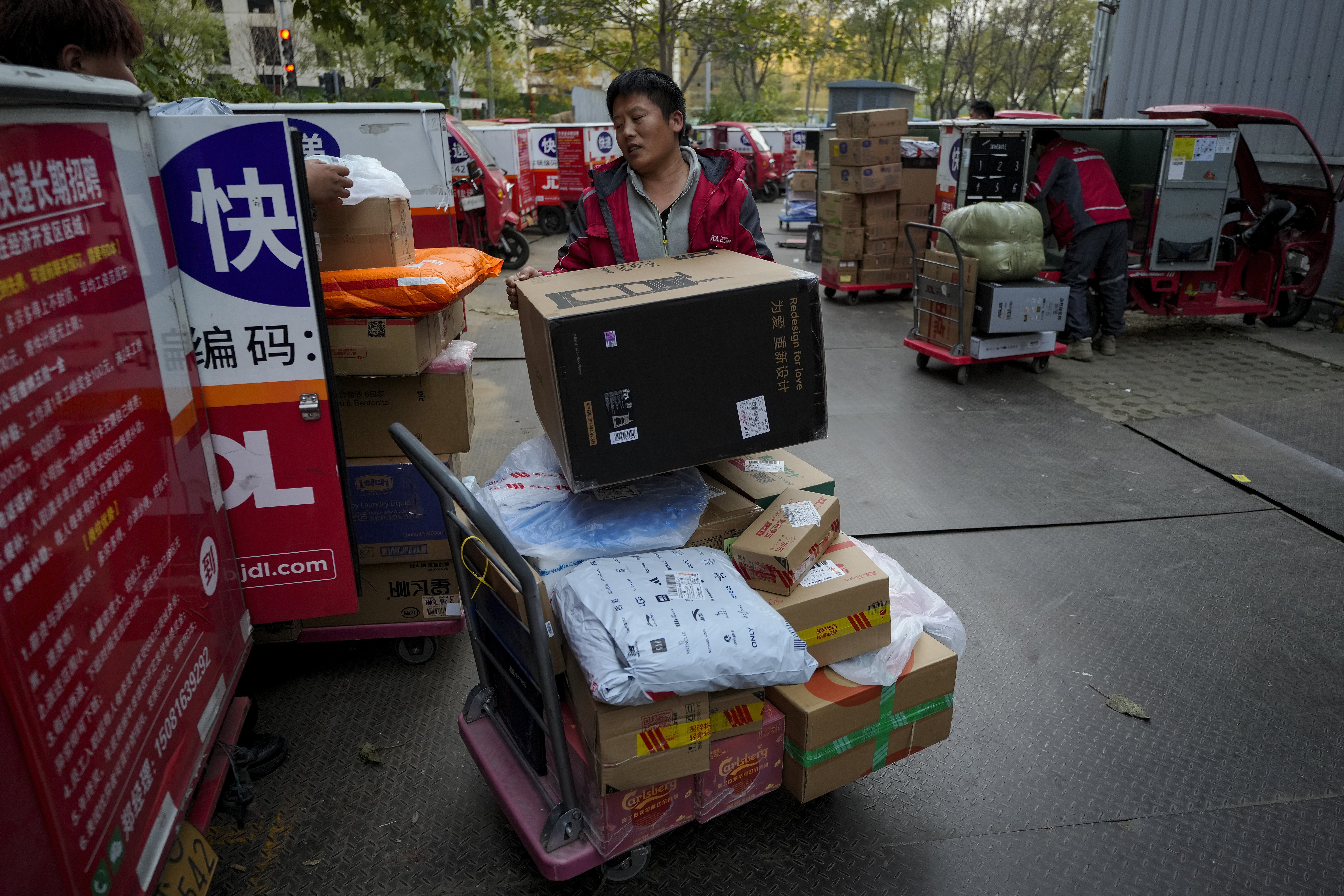 Delivery couriers sort out parcels for their customers at a distribution center for e-commerce platform JD.com in Beijing, Monday, Nov. 11, 2024. (AP Photo/Andy Wong)