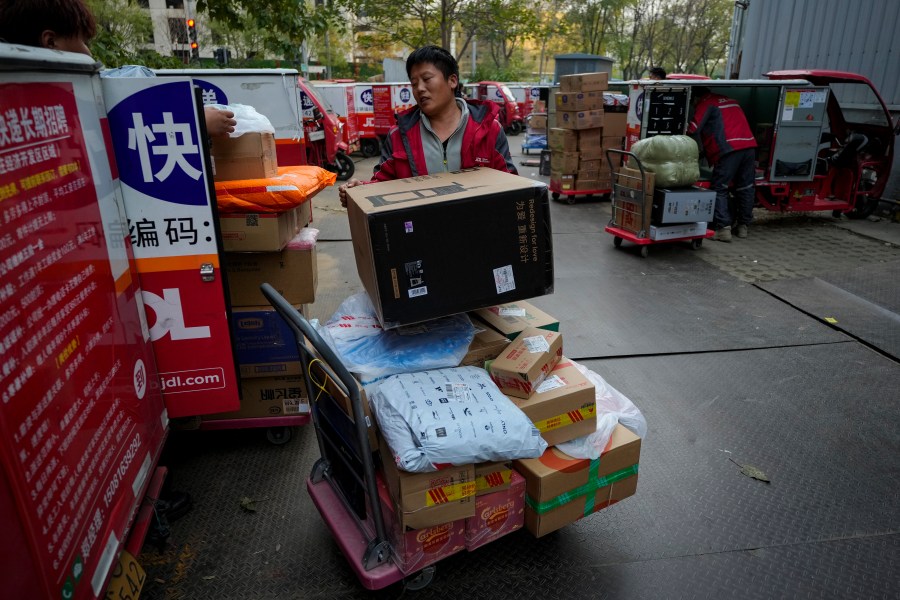 Delivery couriers sort out parcels for their customers at a distribution center for e-commerce platform JD.com in Beijing, Monday, Nov. 11, 2024. (AP Photo/Andy Wong)