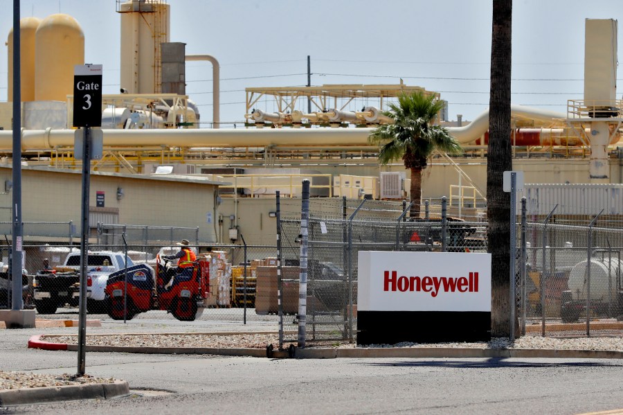 FILE - Construction workers pave a parking lot at a Honeywell plant on April 4, 2020, in Phoenix. (AP Photo/Matt York, File)