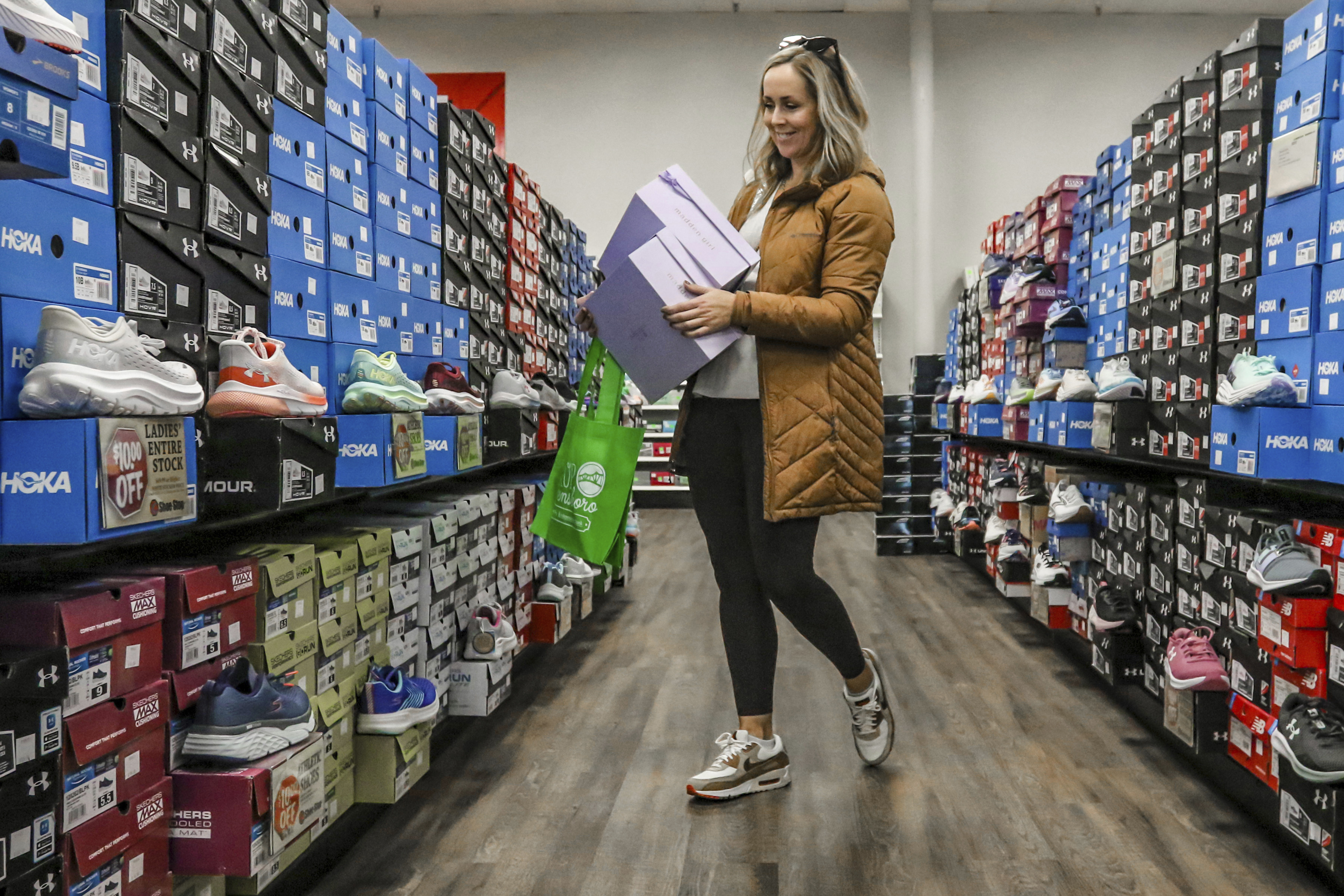 FILE - Ashley Crafton looks at tennis shoes at at Shoe Stop while shopping during Small Business Saturday in Wesleyan Park Plaza on Nov. 25, 2023, in Owensboro, Ky. (Greg Eans/The Messenger-Inquirer via AP, File)