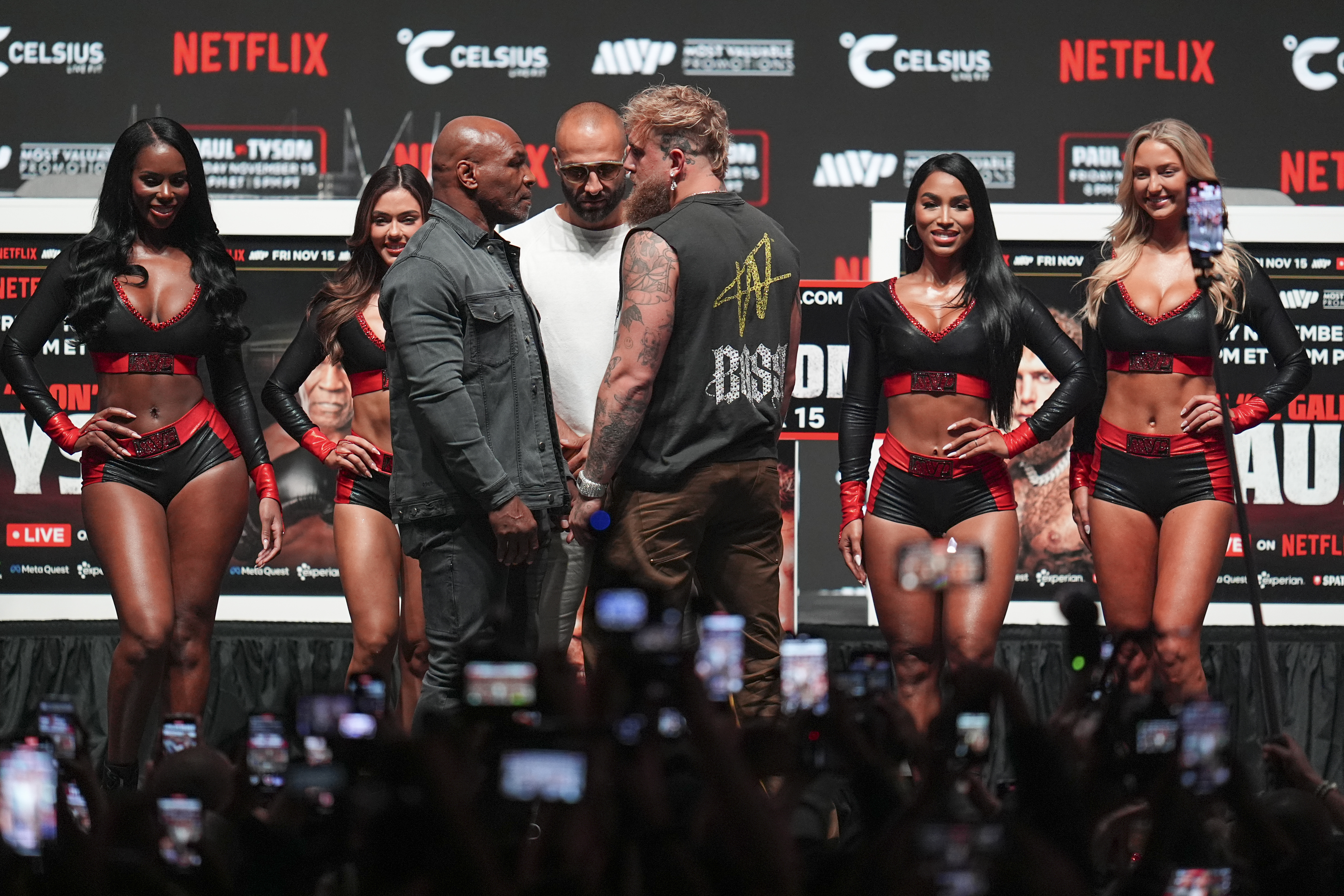 Mike Tyson, front left, and Jake Paul, front right, face off during a news conference ahead of their fight, Wednesday, Nov. 13, 2024, in Irving, Texas. (AP Photo/Julio Cortez)