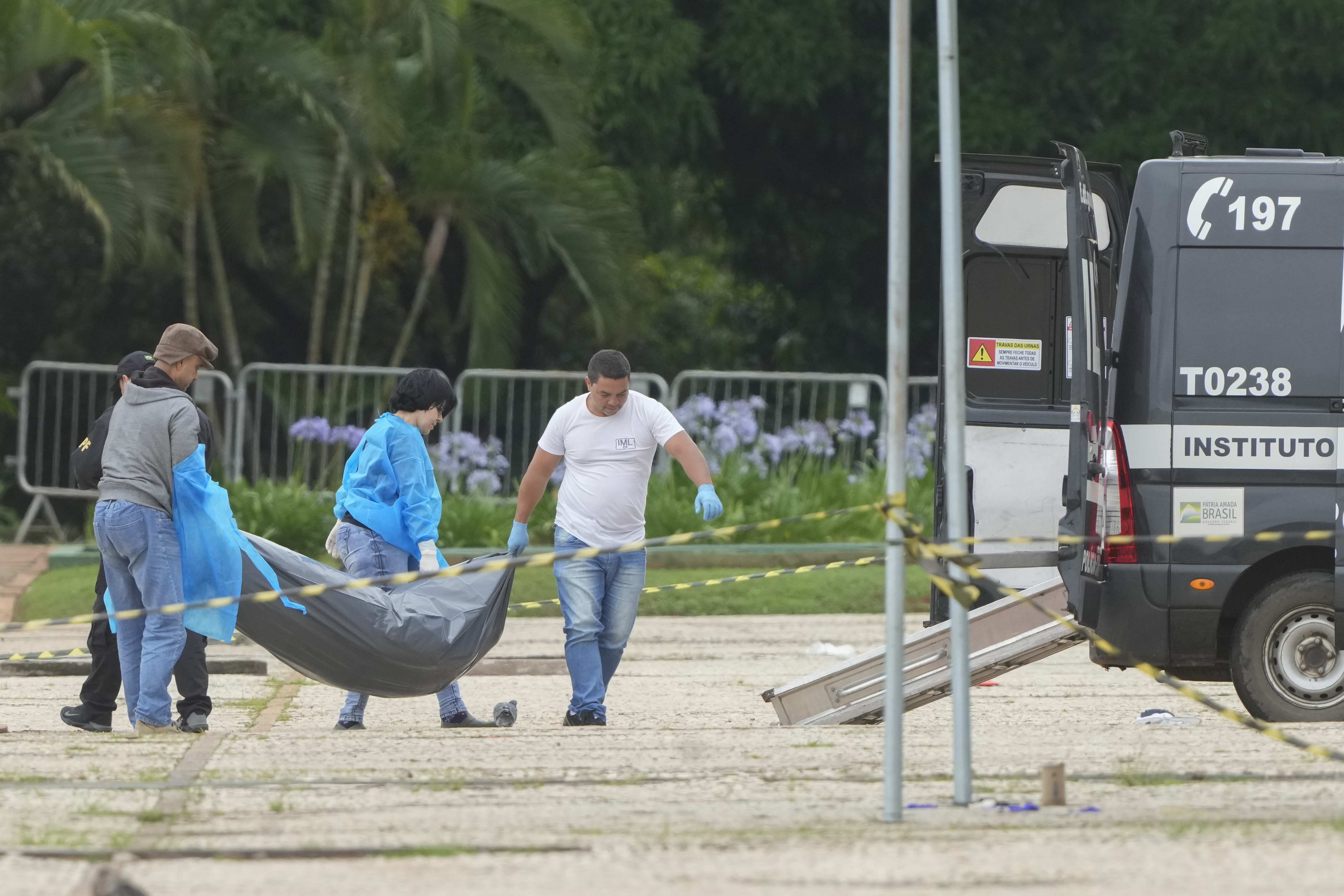 Forensic officers collect a body outside the Supreme Court following an explosion the previous night in Brasilia, Brazil, Thursday, Nov. 14, 2024. (AP Photo/Eraldo Peres)