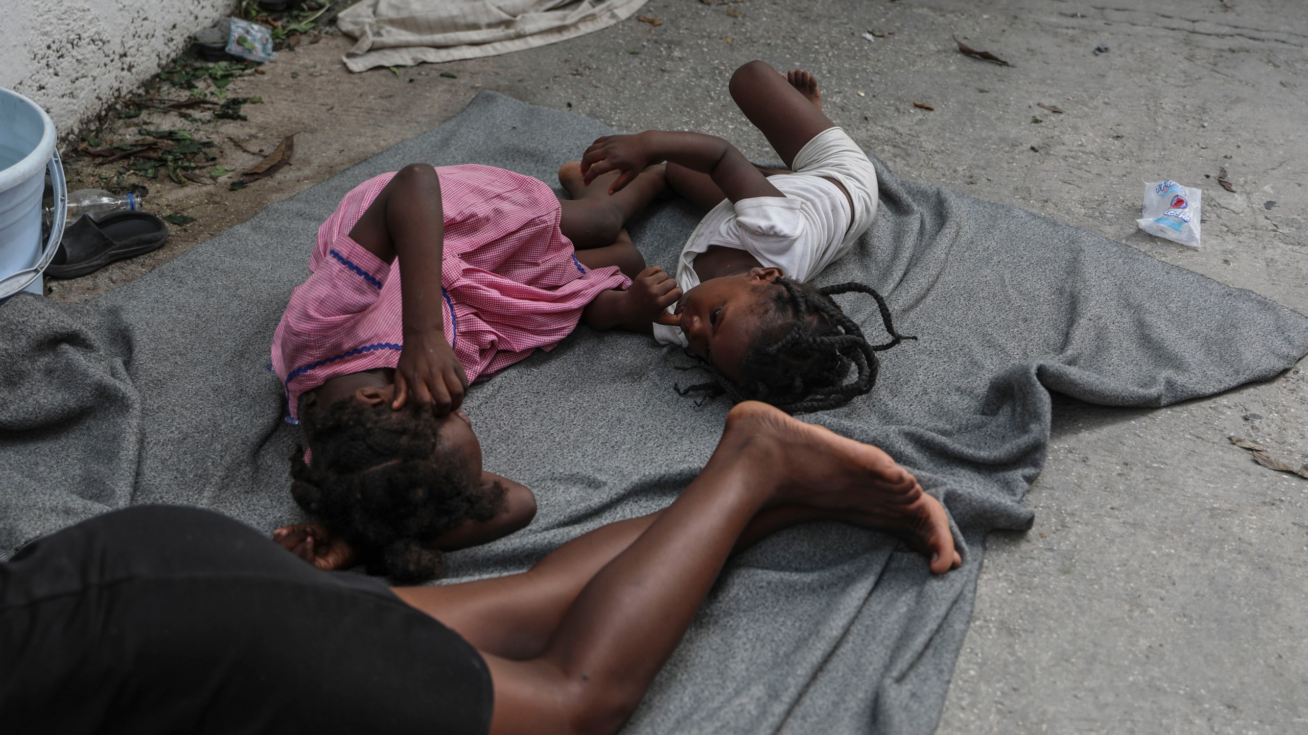 Children sleep on the floor at a school where residents of the Nazon neighborhood displaced by gang violence have sought refuge, in Port-au-Prince, Haiti, Thursday, Nov. 14, 2024. (AP Photo/Odelyn Joseph)