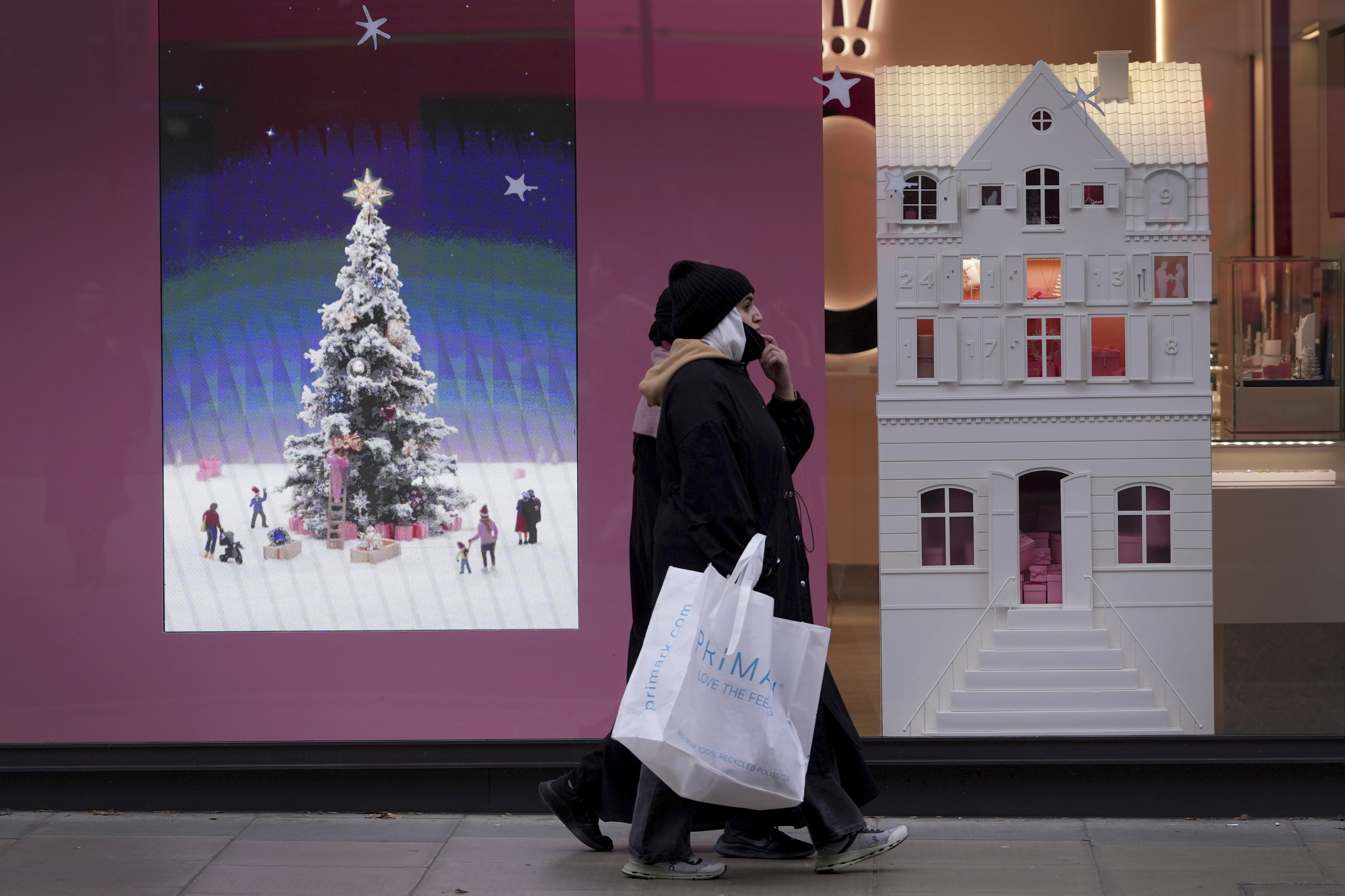 Shoppers pass a festive shop window in Oxford Street in London. Friday, Nov. 15, 2024. (AP Photo/Kirsty Wigglesworth)