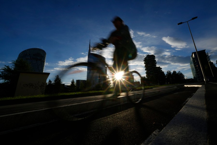 A man bikes as the sun sets in Milan, Italy, Friday, Sept. 13, 2024. (AP Photo/Luca Bruno, file)