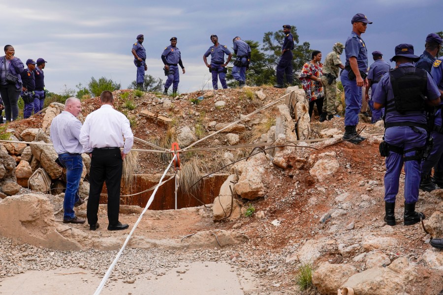 Police officers and private security personnel stand by the opening of a reformed gold mineshaft where illegal miners are trapped in Stilfontein, South Africa, Friday, Nov.15, 2024. (AP Photo/Denis Farrell)