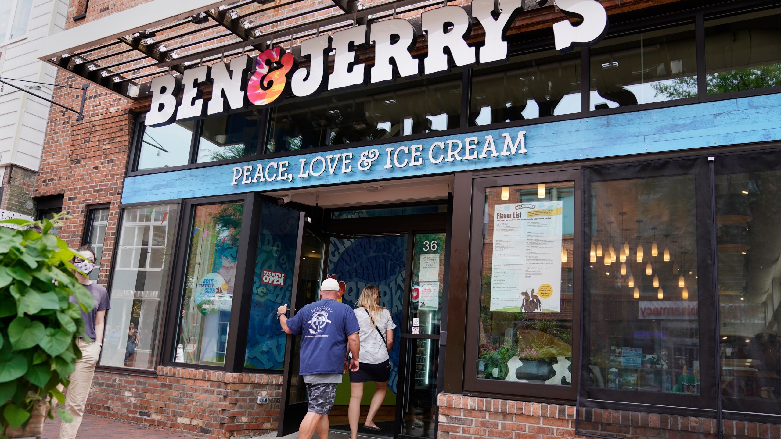 FILE - Two patrons enter the Ben & Jerry's Ice Cream shop, July 20, 2021, in Burlington, Vt. (AP Photo/Charles Krupa, File)