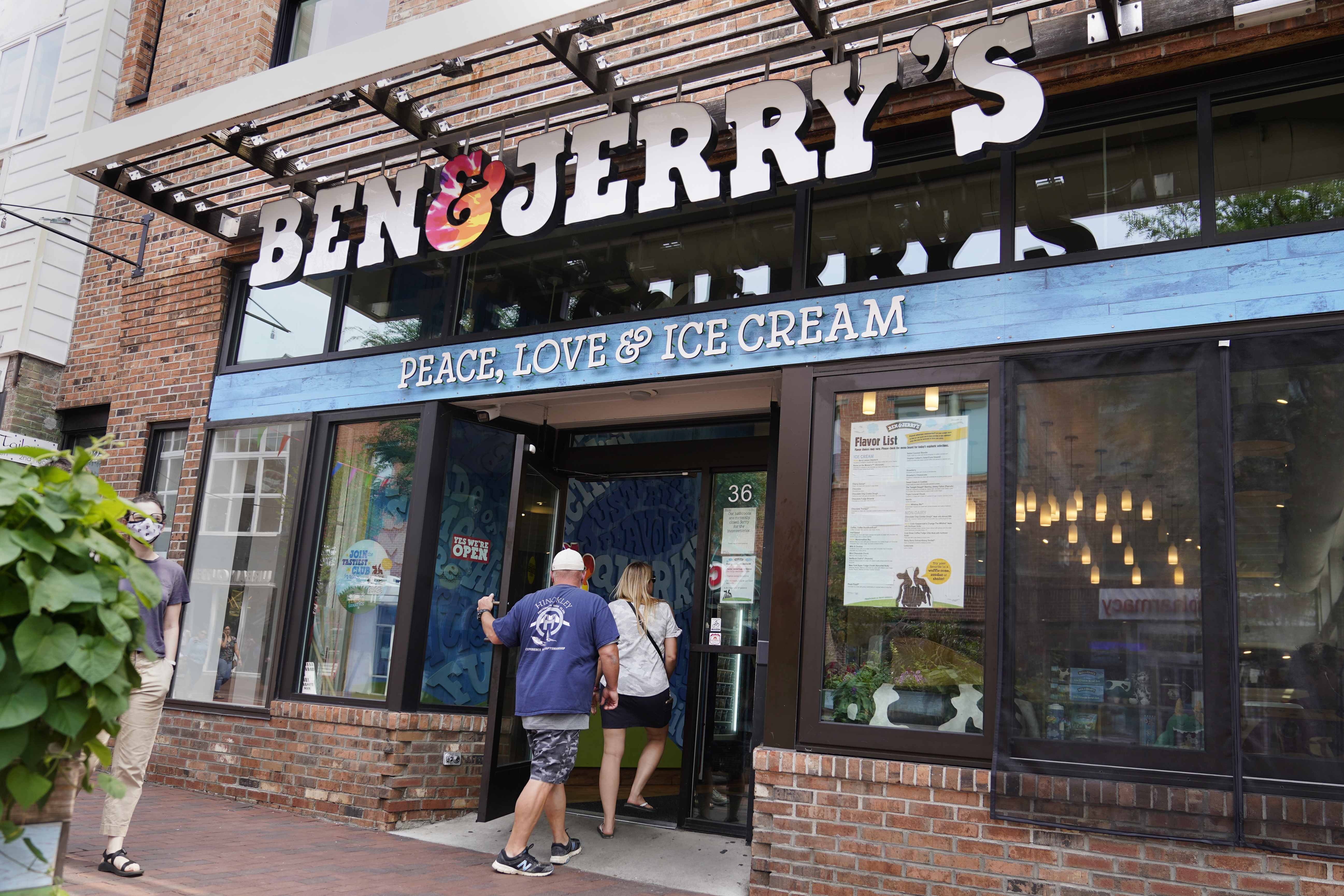 FILE - Two patrons enter the Ben & Jerry's Ice Cream shop, July 20, 2021, in Burlington, Vt. (AP Photo/Charles Krupa, File)