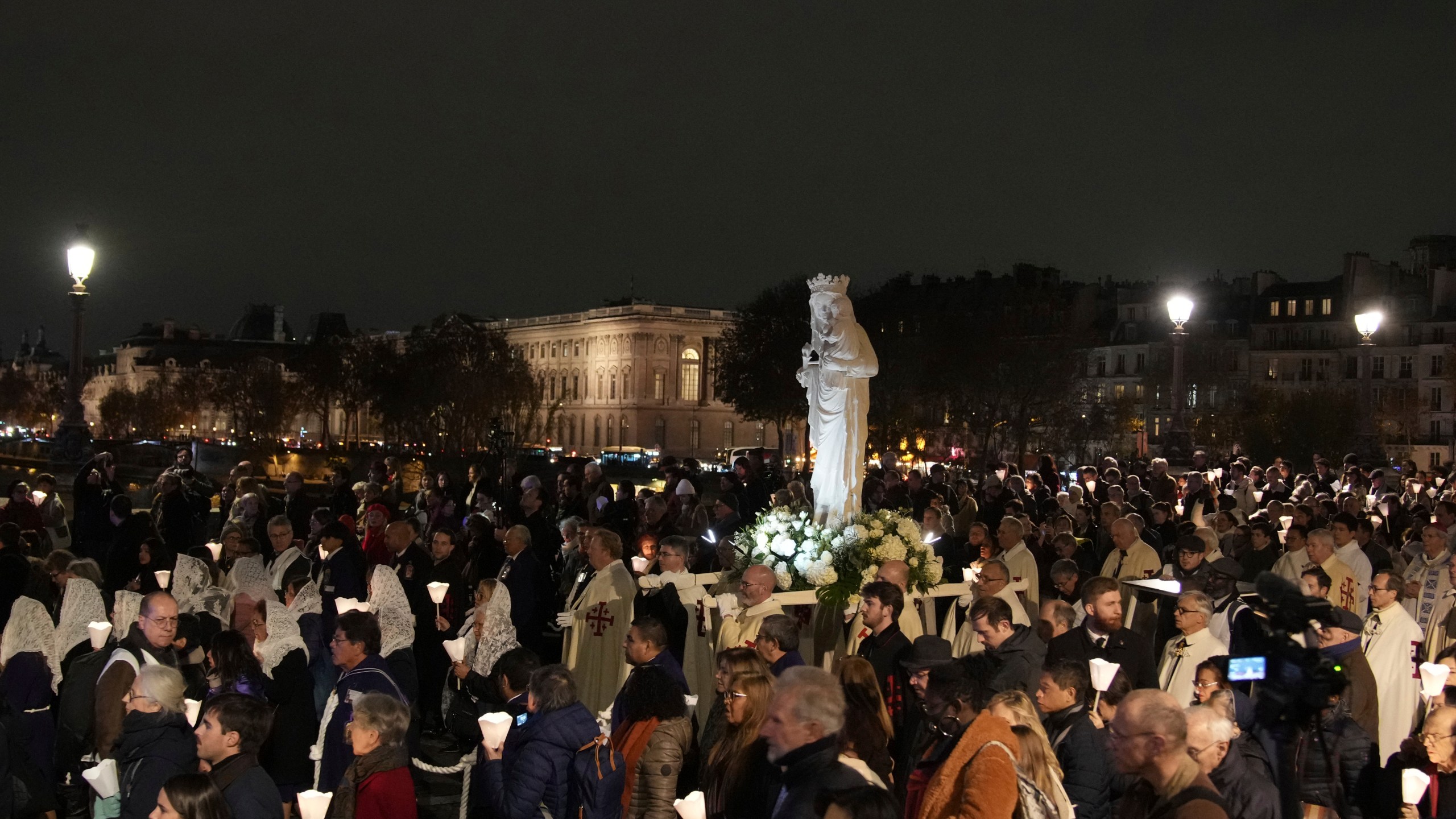 during a procession to bring the Virgin Mary statue from Saint-Germain l'Auxerrois church to Notre-Dame cathedral, Friday, Nov. 15, 2024 in Paris. (AP Photo/Christophe Ena)