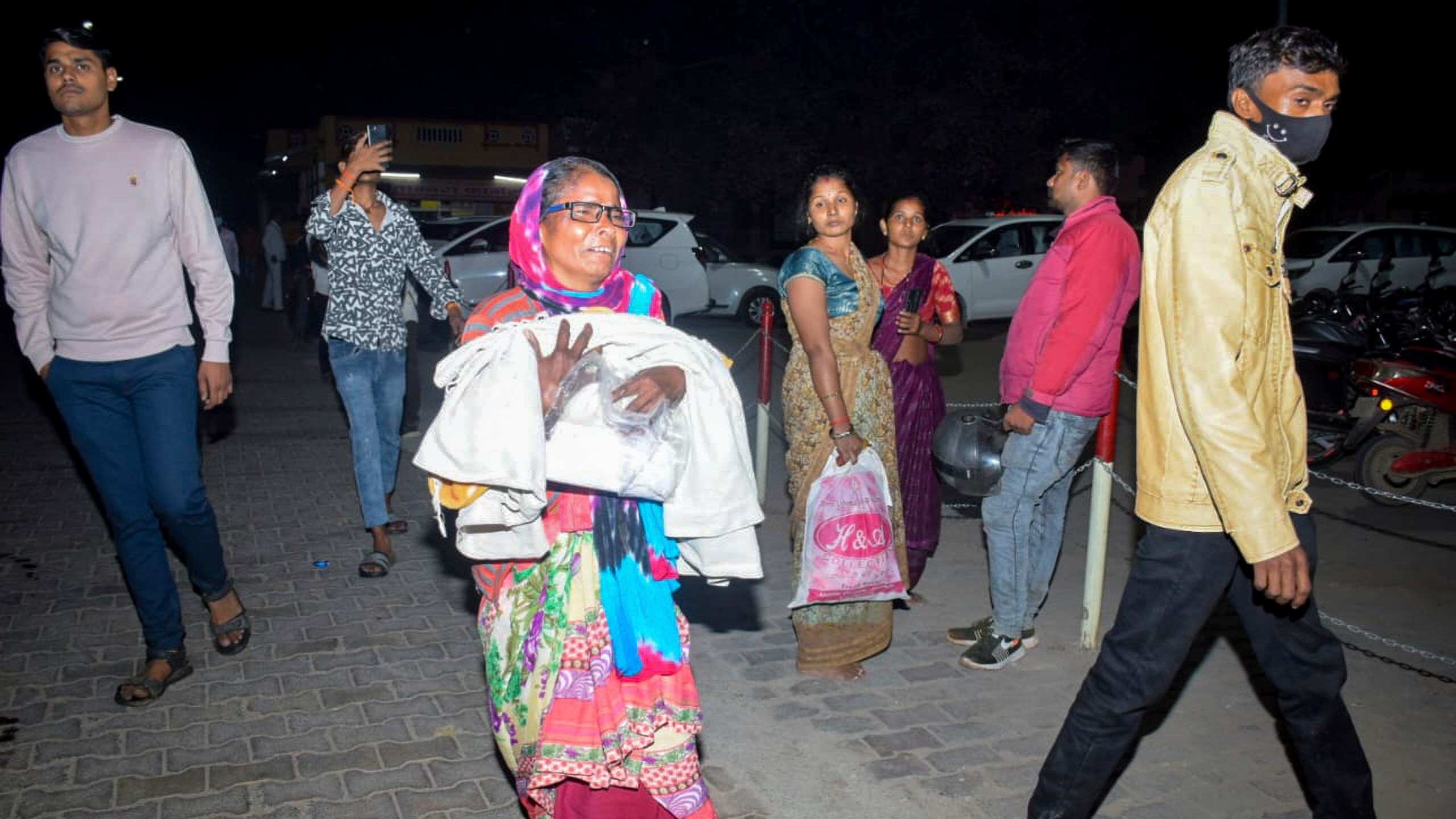 A woman rushes a child to the emergency ward after a fire broke out in a neonatal intensive care unit at Jhansi Medical College hospital in Jhansi, India, Friday, Nov. 15, 2024. (AP Photo)