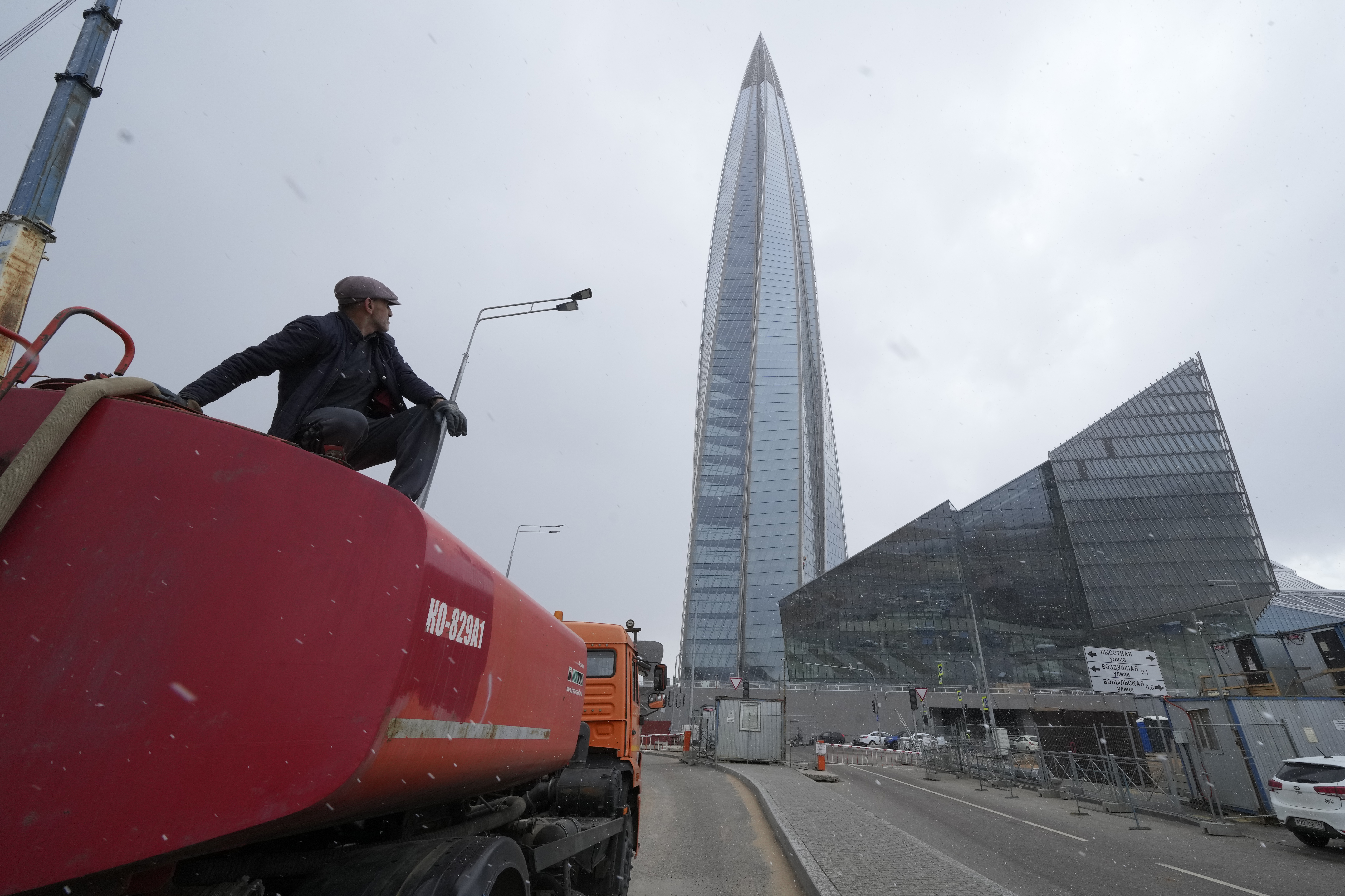 FILE - A worker sits on his water tank truck next to the business tower Lakhta Centre, the headquarters of Russian gas monopoly Gazprom in St. Petersburg, Russia, April 27, 2022. (AP Photo/Dmitri Lovetsky, File)