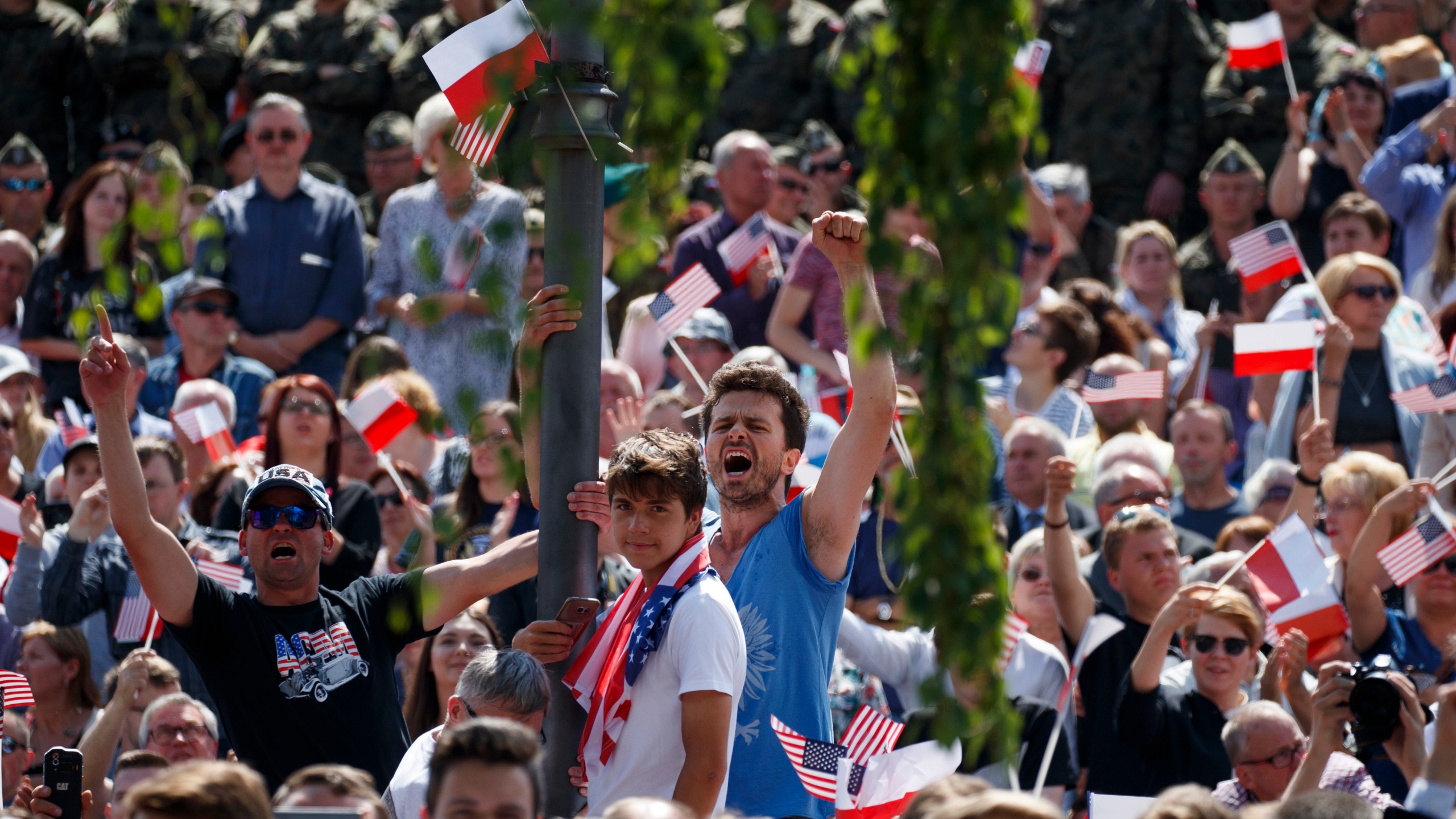 FILE - People cheer as US President Donald Trump delivers a speech at Krasinski Square at the Royal Castle, July 6, 2017, in Warsaw. (AP Photo/Evan Vucci, File)