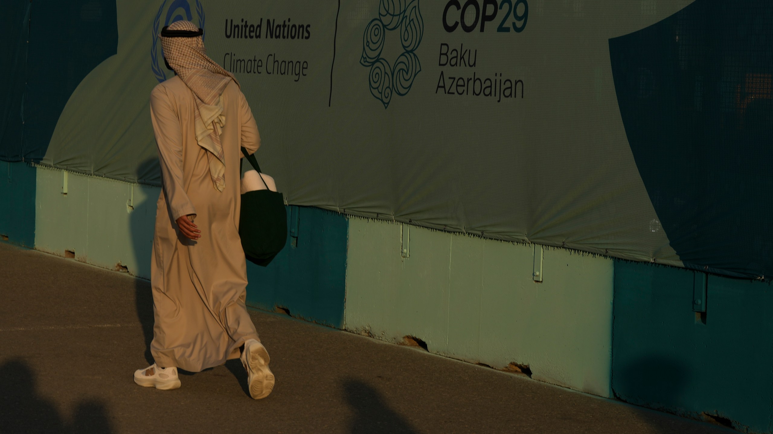 A person walks past a sign for the COP29 U.N. Climate Summit, Friday, Nov. 15, 2024, in Baku, Azerbaijan. (AP Photo/Peter Dejong)