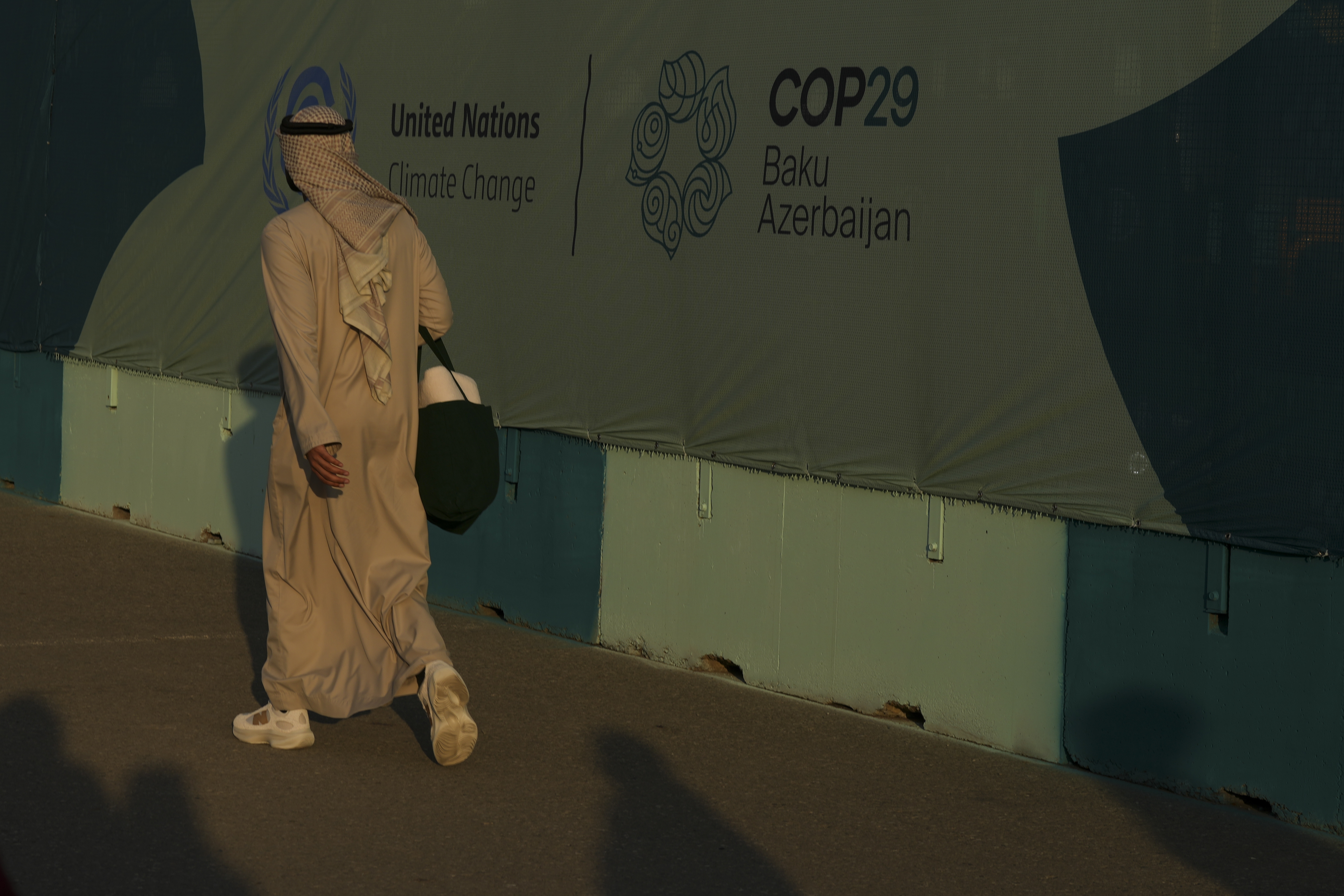 A person walks past a sign for the COP29 U.N. Climate Summit, Friday, Nov. 15, 2024, in Baku, Azerbaijan. (AP Photo/Peter Dejong)