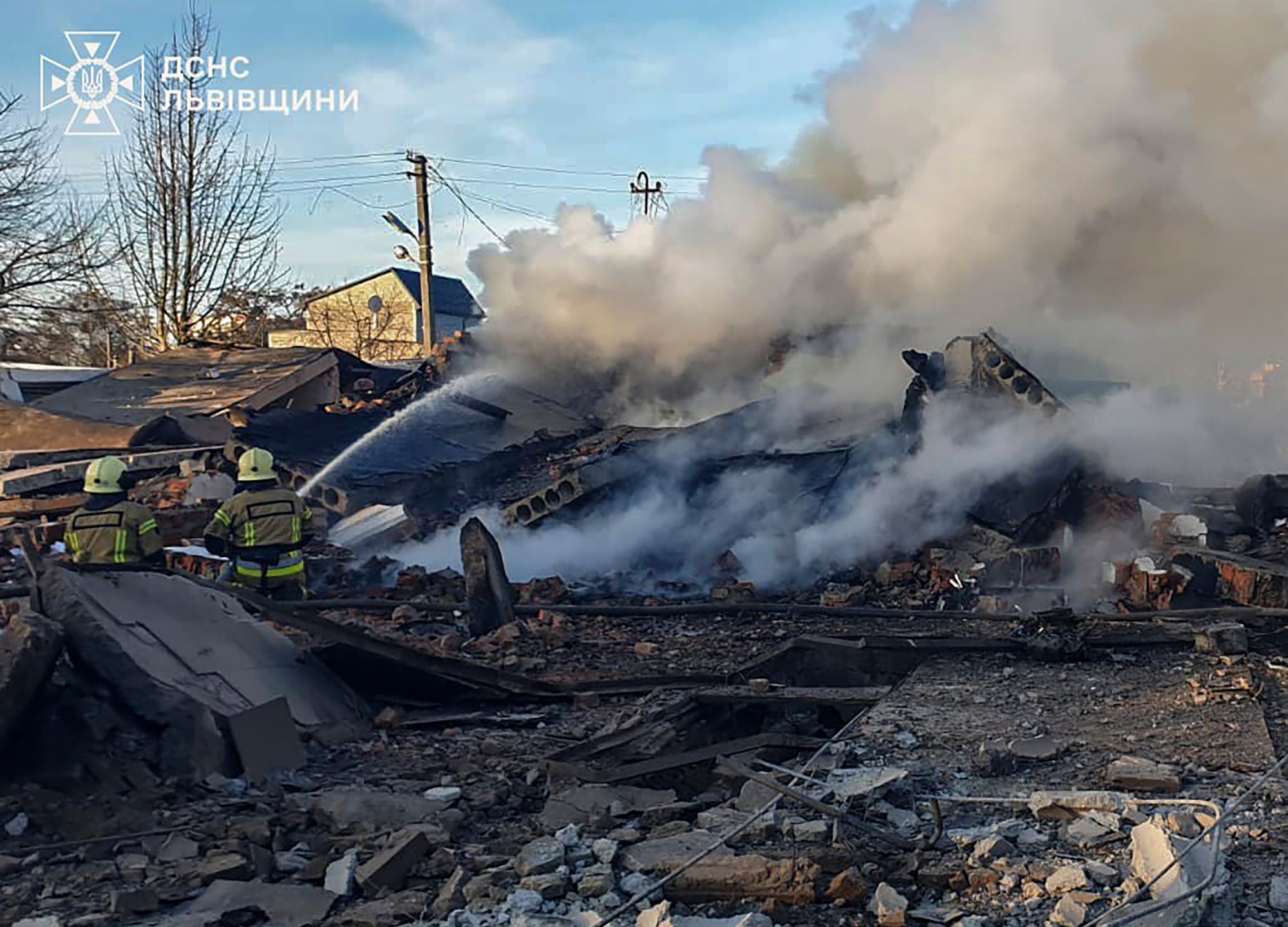 In this photo provided by the Ukrainian Emergency Service, emergency services personnel work to extinguish a fire following a Russian rocket attack in Lviv, Ukraine, Sunday, Nov. 17, 2024. (Ukrainian Emergency Service via AP)