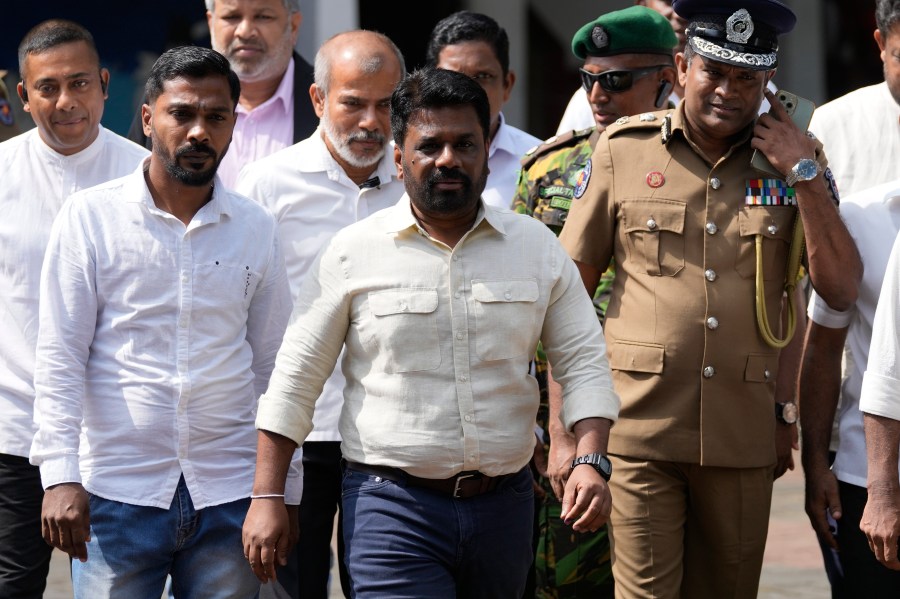 Sri Lankan President Anura Kumara Dissanayake, center, leaves after casting his vote during the parliamentary election in Colombo, Sri Lanka, Thursday, Nov. 14, 2024.(AP Photo/Eranga Jayawardena)