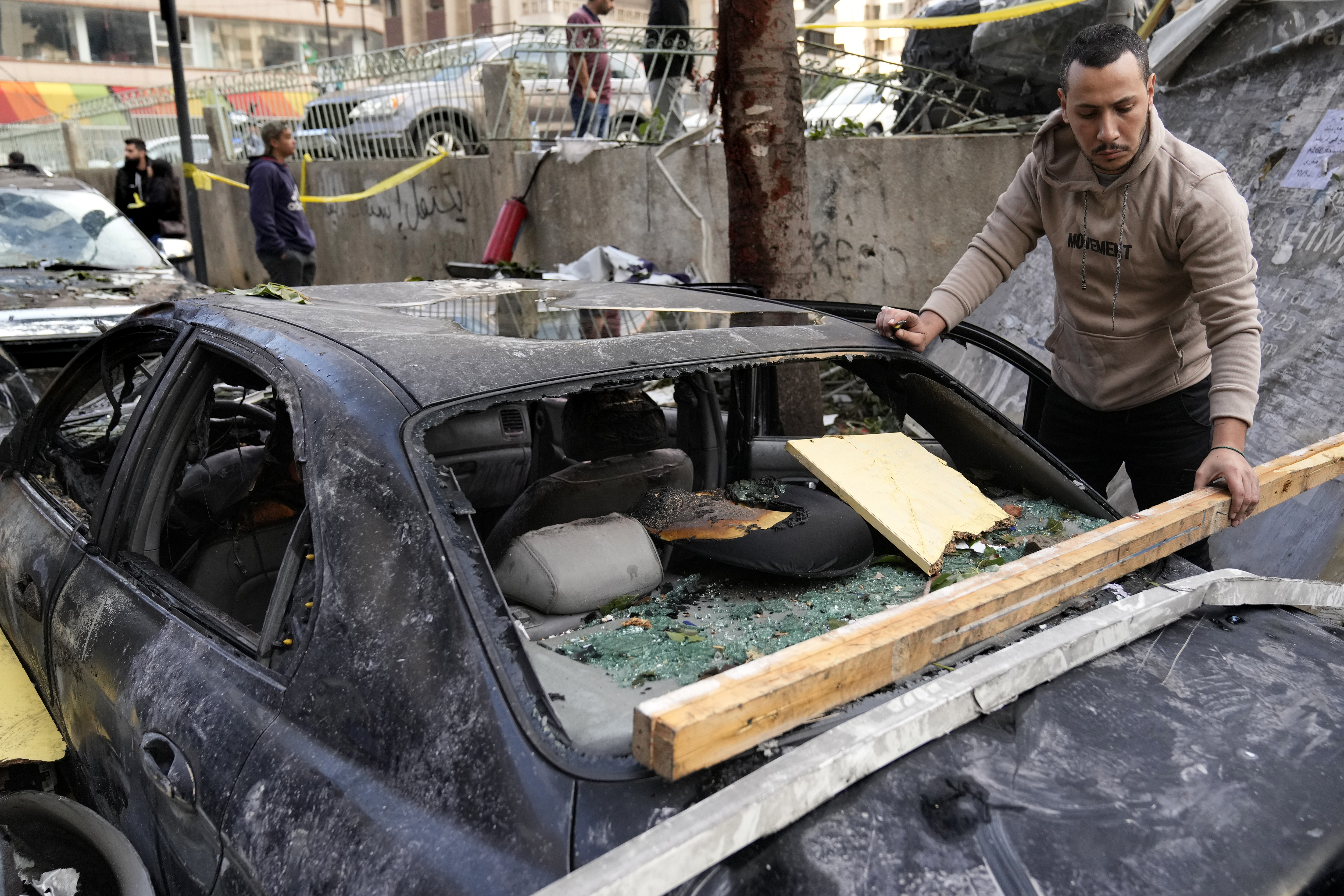 A man removes debris from his damaged car at the site where an Israeli airstrike on Sunday evening hit in central Beirut, Lebanon, Monday, Nov. 18, 2024. (AP Photo/Hussein Malla)