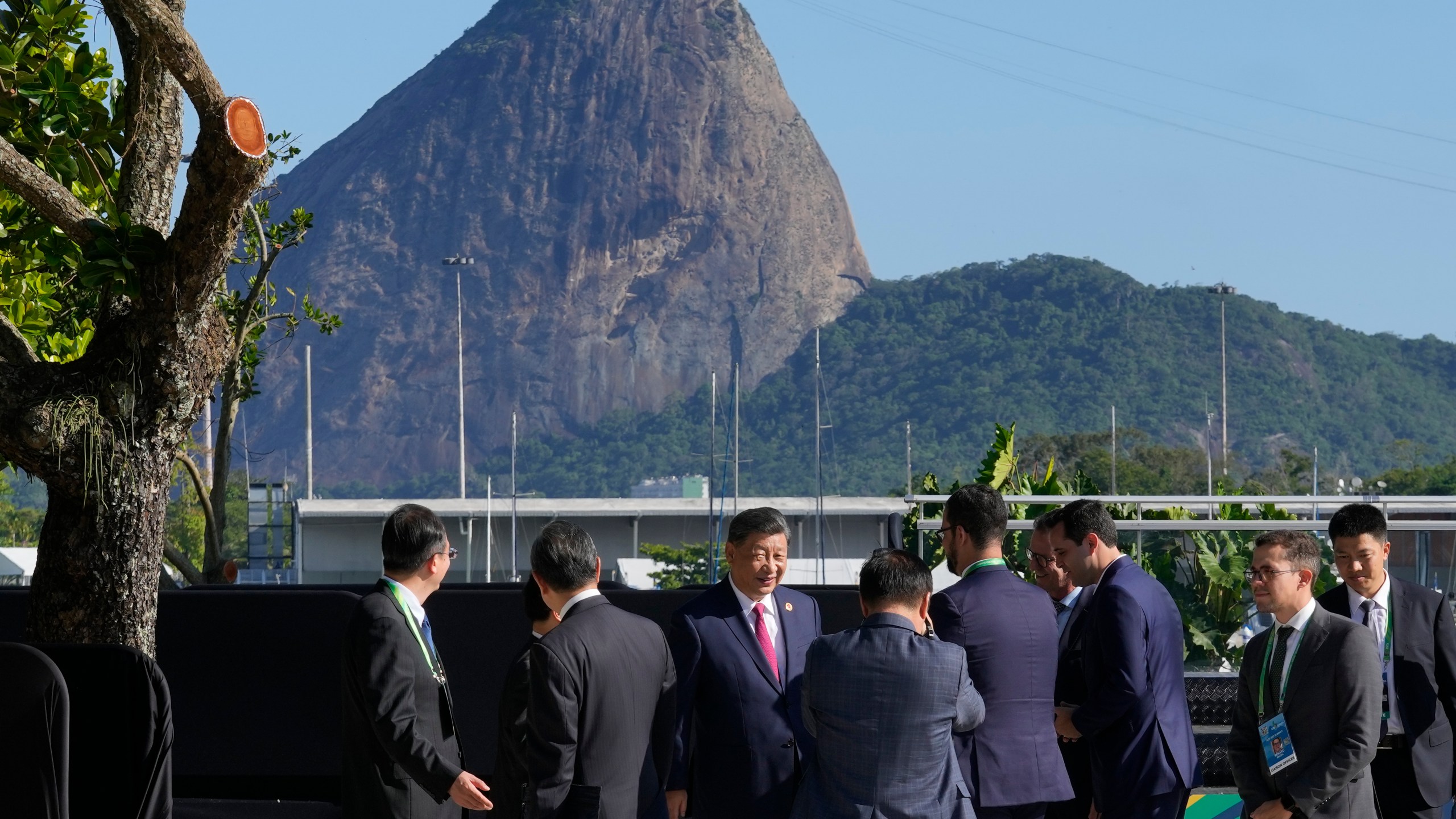 Backdropped by Sugar Loaf mountain, China's President Xi Jinping, center, walks after joining a group photo during the G20 Summit in Rio de Janeiro, Monday, Nov. 18, 2024. (AP Photo/Eraldo Peres)