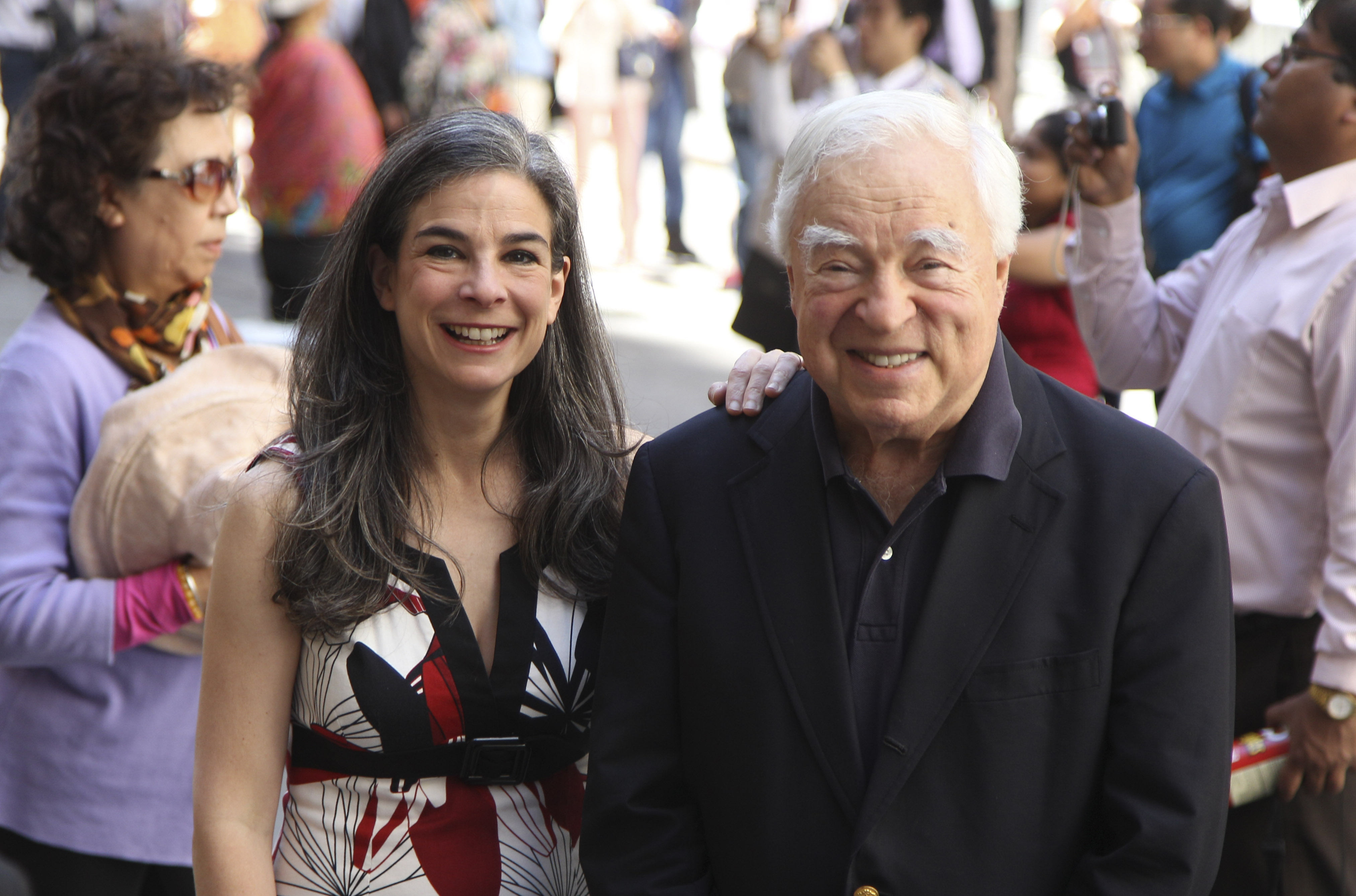 FILE - Arthur Frommer, 83, and his daughter, Pauline Frommer, 46, pose among tourists in the Wall Street area in New York, May 20, 2012. (AP Photo/Seth Wenig, File)