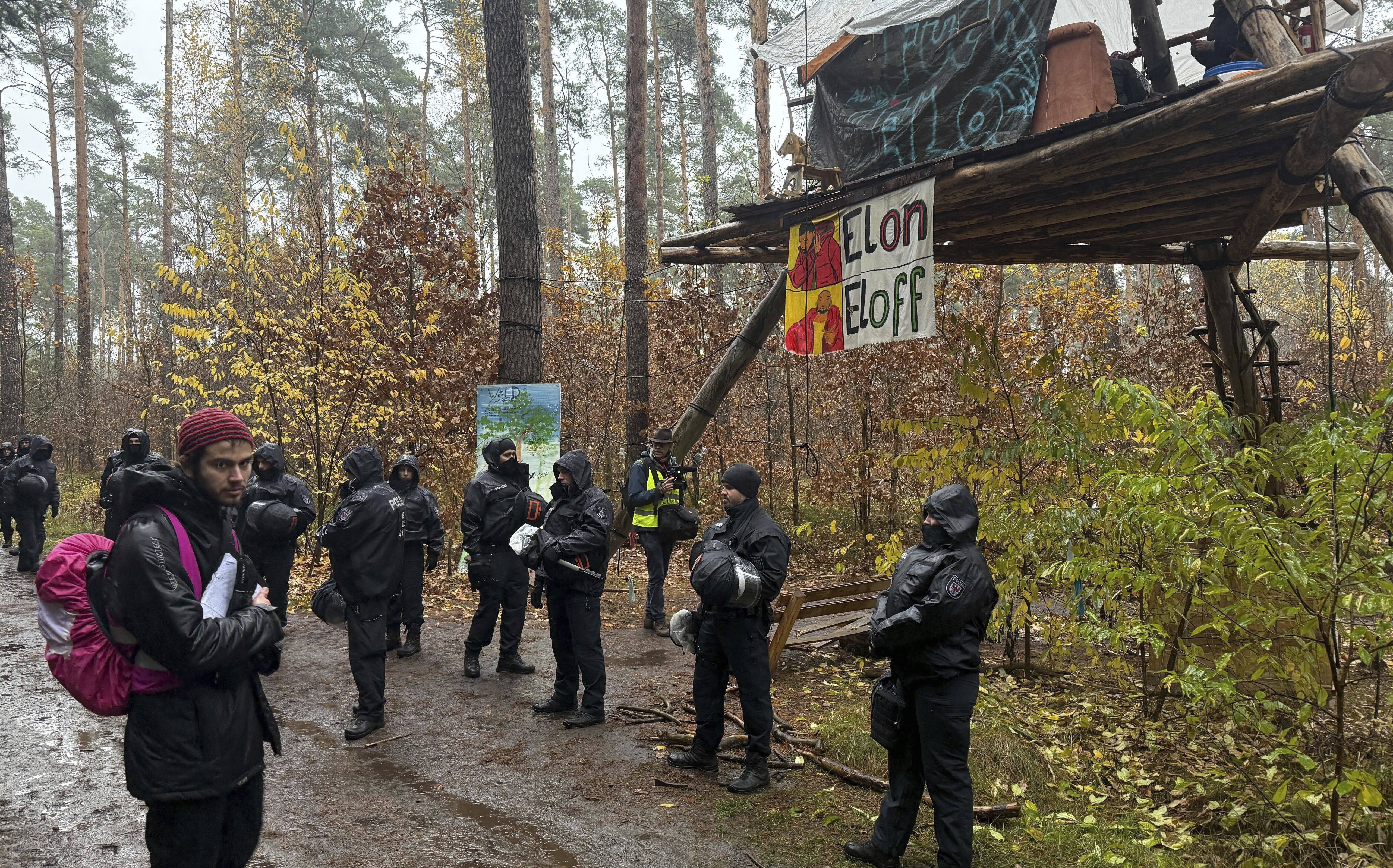 Police officers break up a protest camp housing environmental activists at the Tesla protest camp in the forest near the car factory in Grünheide, Germany, Tuesday Nov. 19, 2024. (Lutz Deckwerth/dpa via AP)