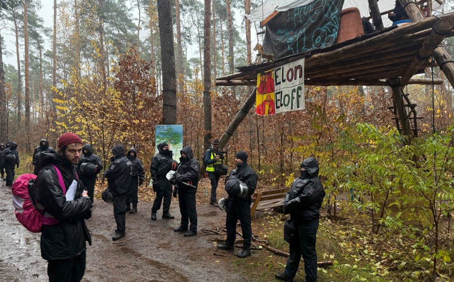 Police officers break up a protest camp housing environmental activists at the Tesla protest camp in the forest near the car factory in Grünheide, Germany, Tuesday Nov. 19, 2024. (Lutz Deckwerth/dpa via AP)