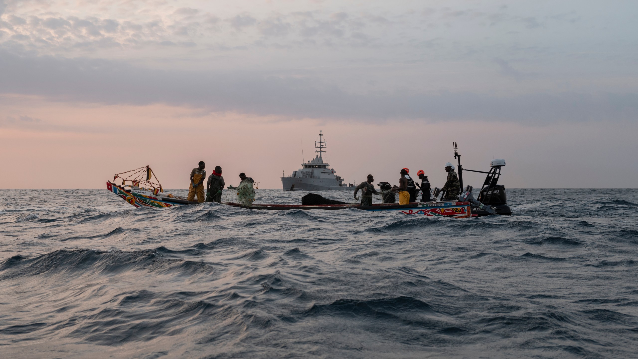 Senegalese sailors in their zodiac, background, approach a fishermen's pirogue to check during a mission to search for illegal migrant boats near the coast of Dakar, Senegal, Saturday, Nov.16, 2024. (AP Photo/Sylvain Cherkaoui)