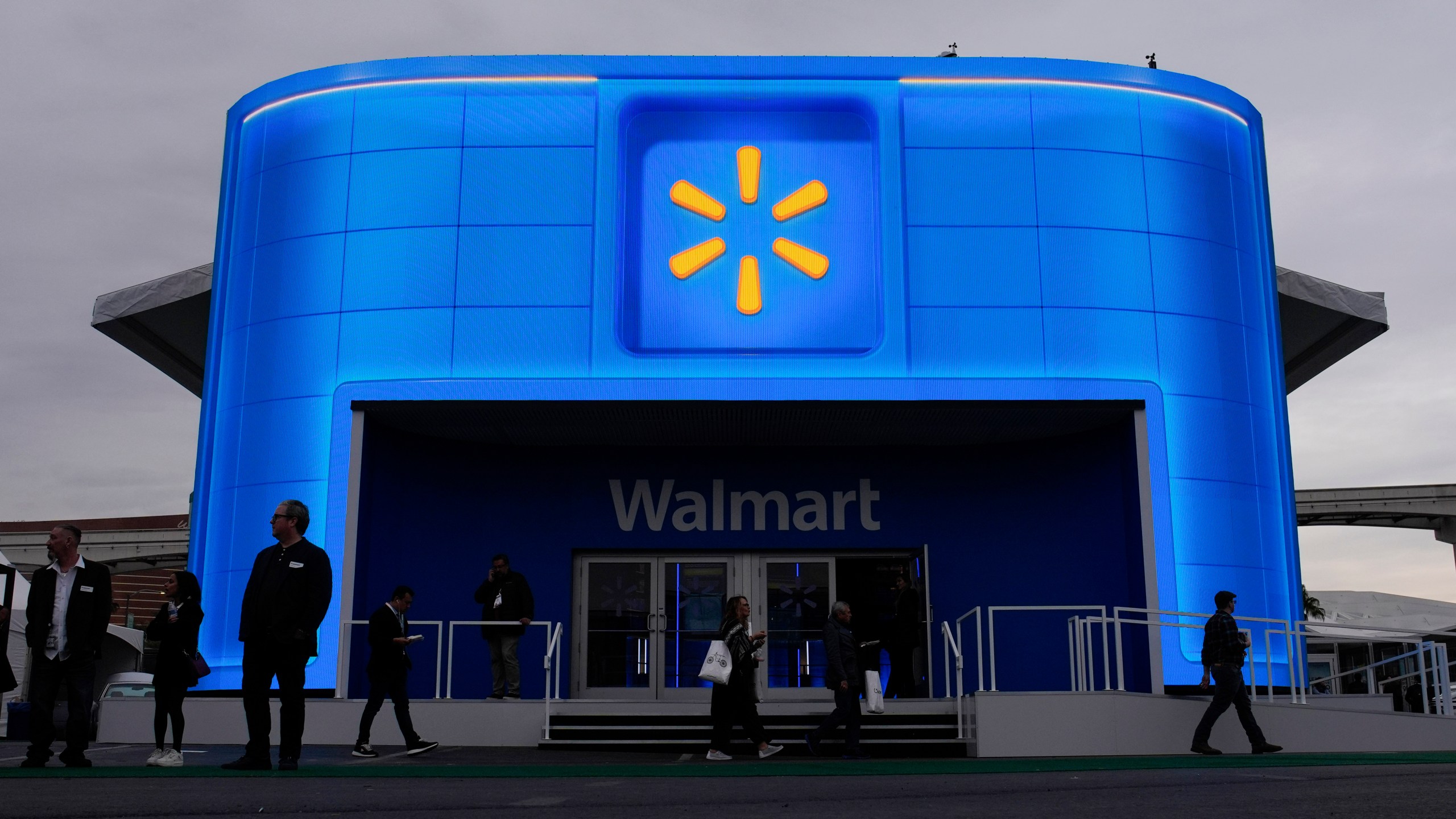 FILE - People walk by the Walmart booth during the CES tech show on Jan. 9, 2024, in Las Vegas. (AP Photo/John Locher, File)