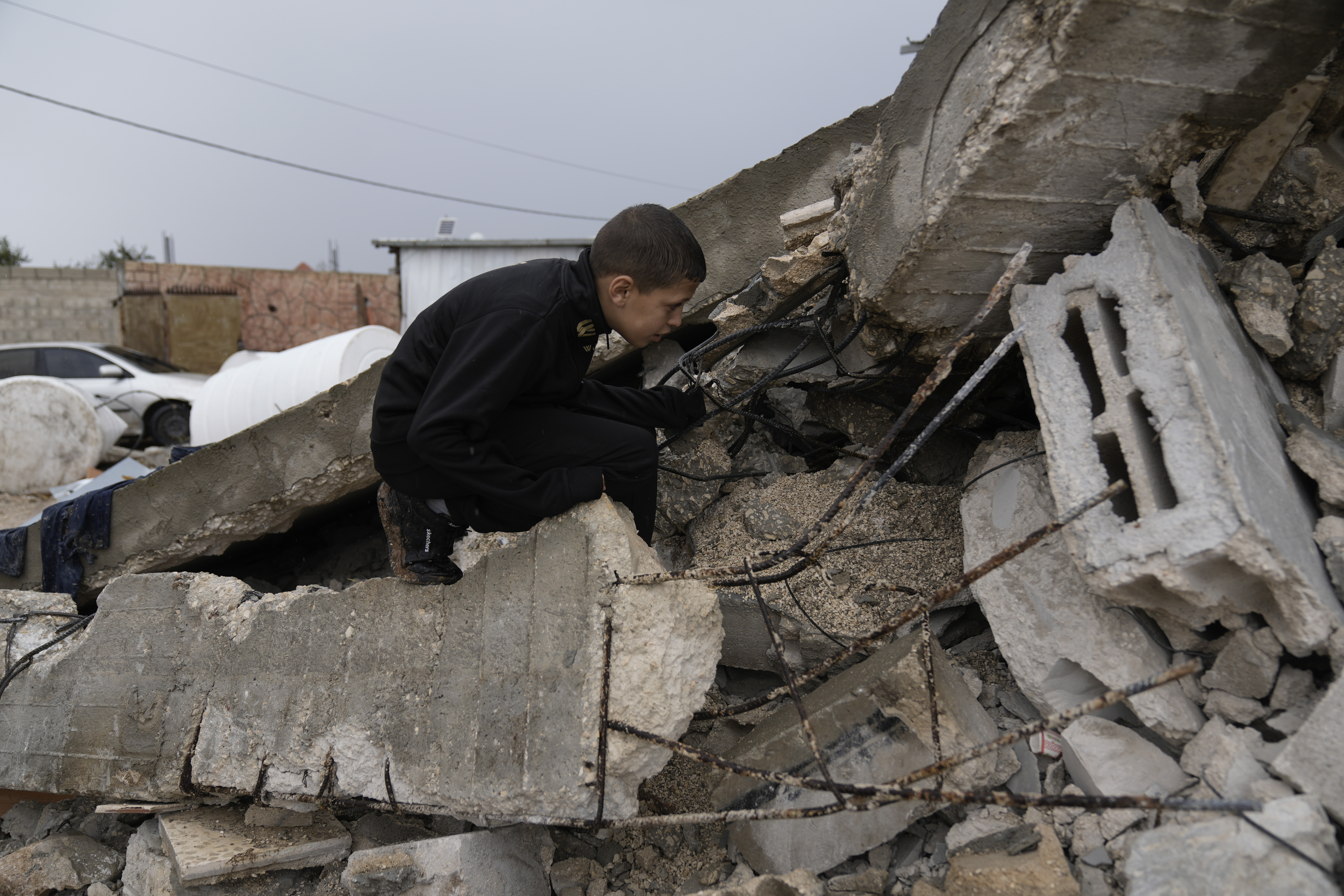 A Palestinian child survey the wreckage left by an Israeli raid in the West Bank city of Jenin, Tuesday, Nov. 19, 2024. (AP Photo/Majdi Mohammed).