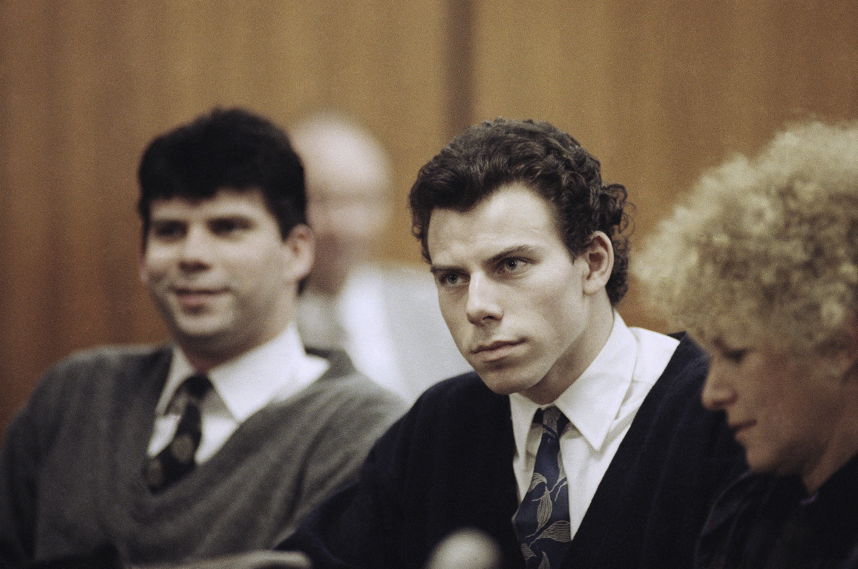 FILE - Lyle, left, and Erik Menendez sit with defense attorney Leslie Abramson, right, in the Municipal Court in the Beverly Hills area of Los Angeles, during a hearing, Nov. 26, 1990. (AP Photo/Nick Ut, File)