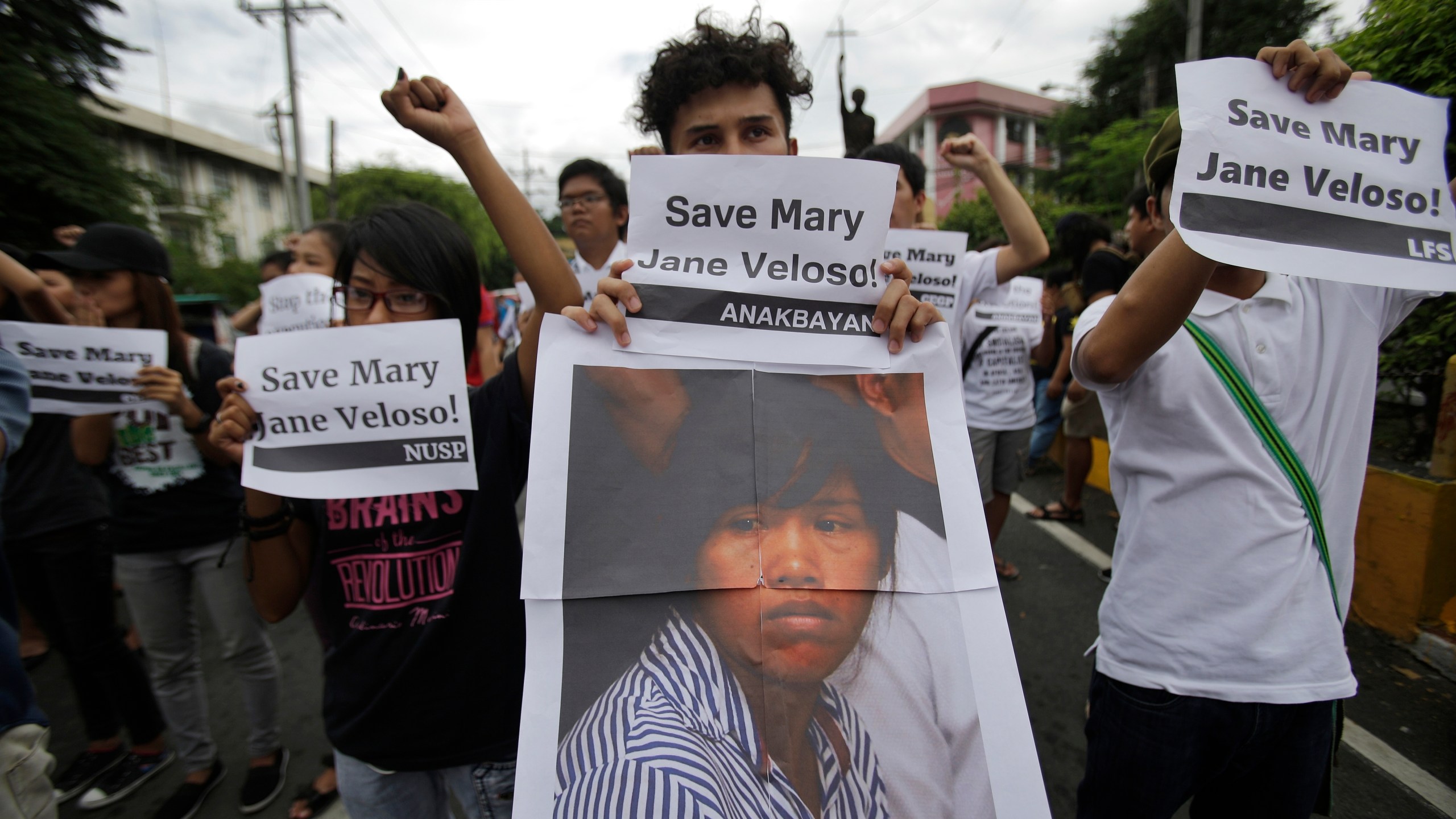 FILE - Protesters hold a picture of Mary Jane Veloso, a Filipino convicted drug trafficker in Indonesia, as they urge Philippine President save her from execution during a rally in Manila, Philippines on Tuesday, Sept. 13, 2016. (AP Photo/Aaron Favila, File)