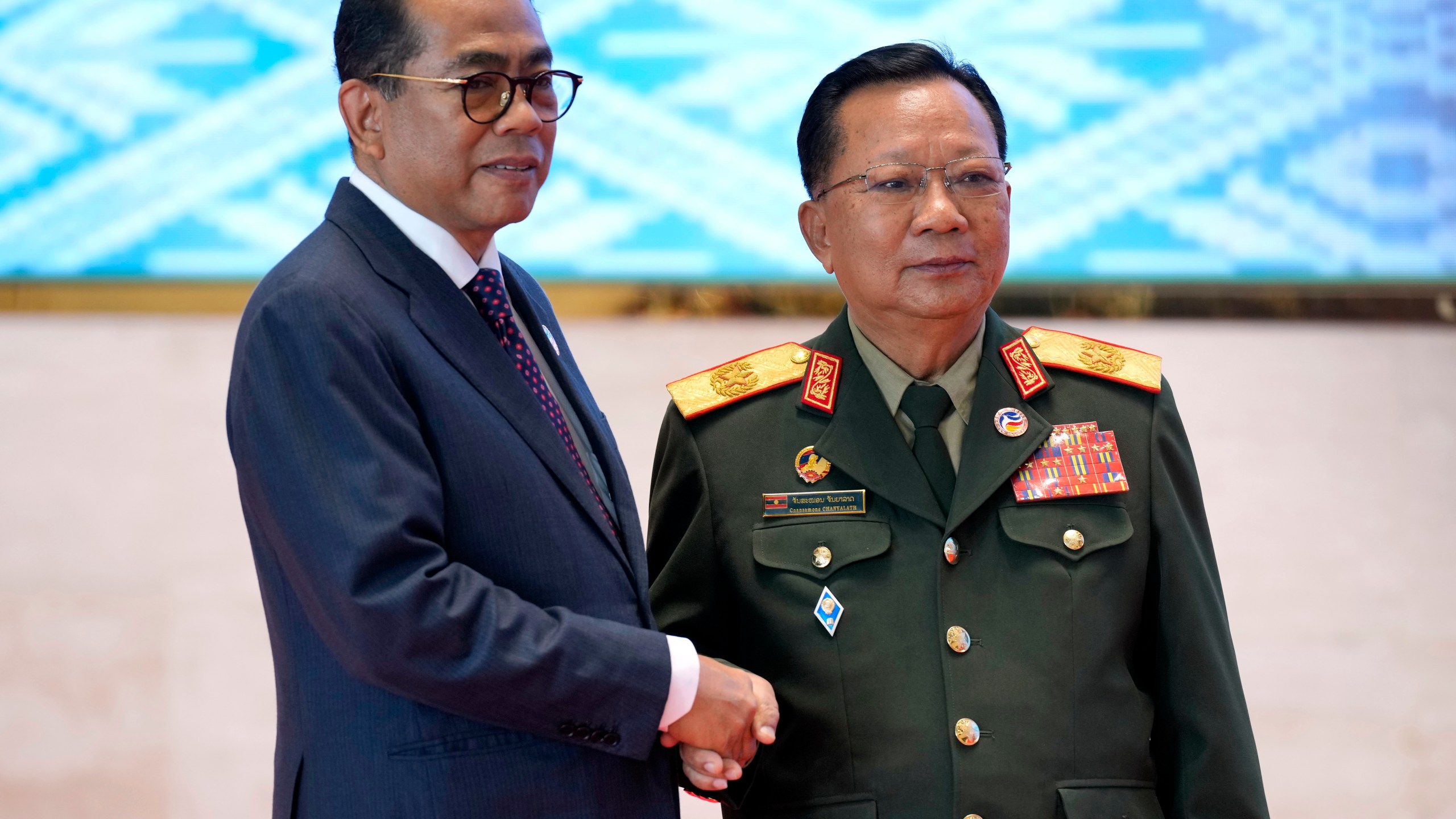 Laos' Defense Minister Chansamone Chanyalath, right, greets Malaysian Defence Minister Mohamed Khaled Nordin during the Association of Southeast Asian Nations (ASEAN) defense ministers' meeting in Vientiane, Laos, Wednesday, Nov. 20, 2024. (AP Photo/Anupam Nath)