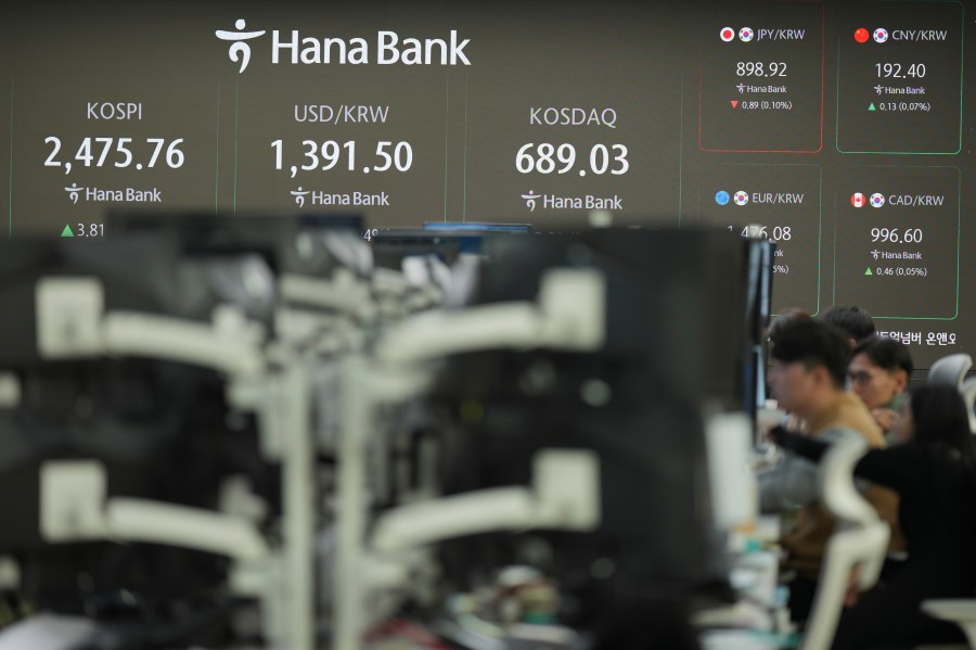 Currency traders watch their computer monitors near the screens showing the Korea Composite Stock Price Index (KOSPI), left, the foreign exchange rate between U.S. dollar and South Korean won, center, and the Korean Securities Dealers Automated Quotations (KOSDAQ), at a foreign exchange dealing room in Seoul, South Korea, Wednesday, Nov. 20, 2024. (AP Photo/Lee Jin-man)