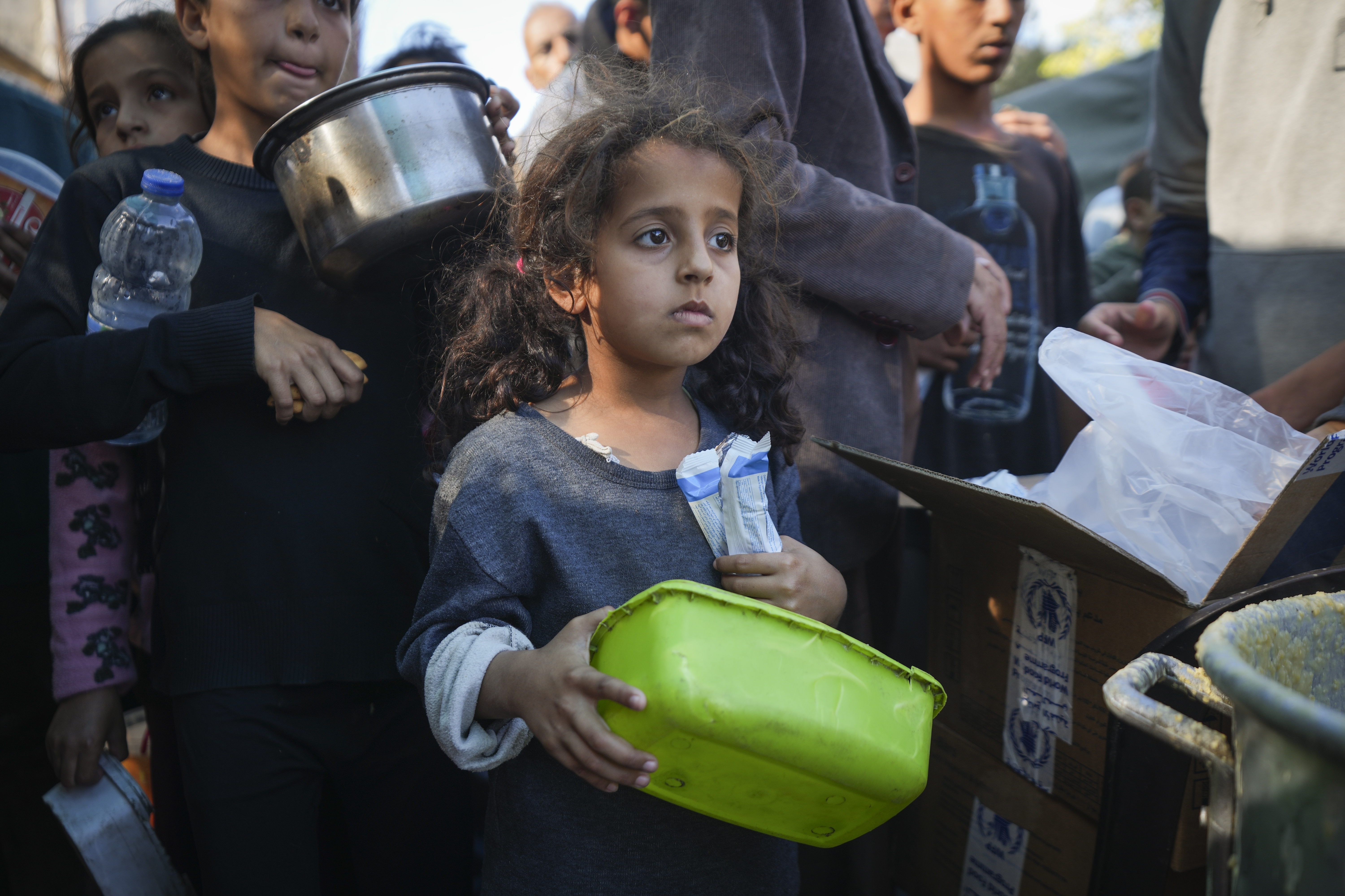 A Palestinian little girl queues for food in Deir al-Balah, Gaza Strip, Monday, Nov. 18, 2024. (AP Photo/Abdel Kareem Hana)