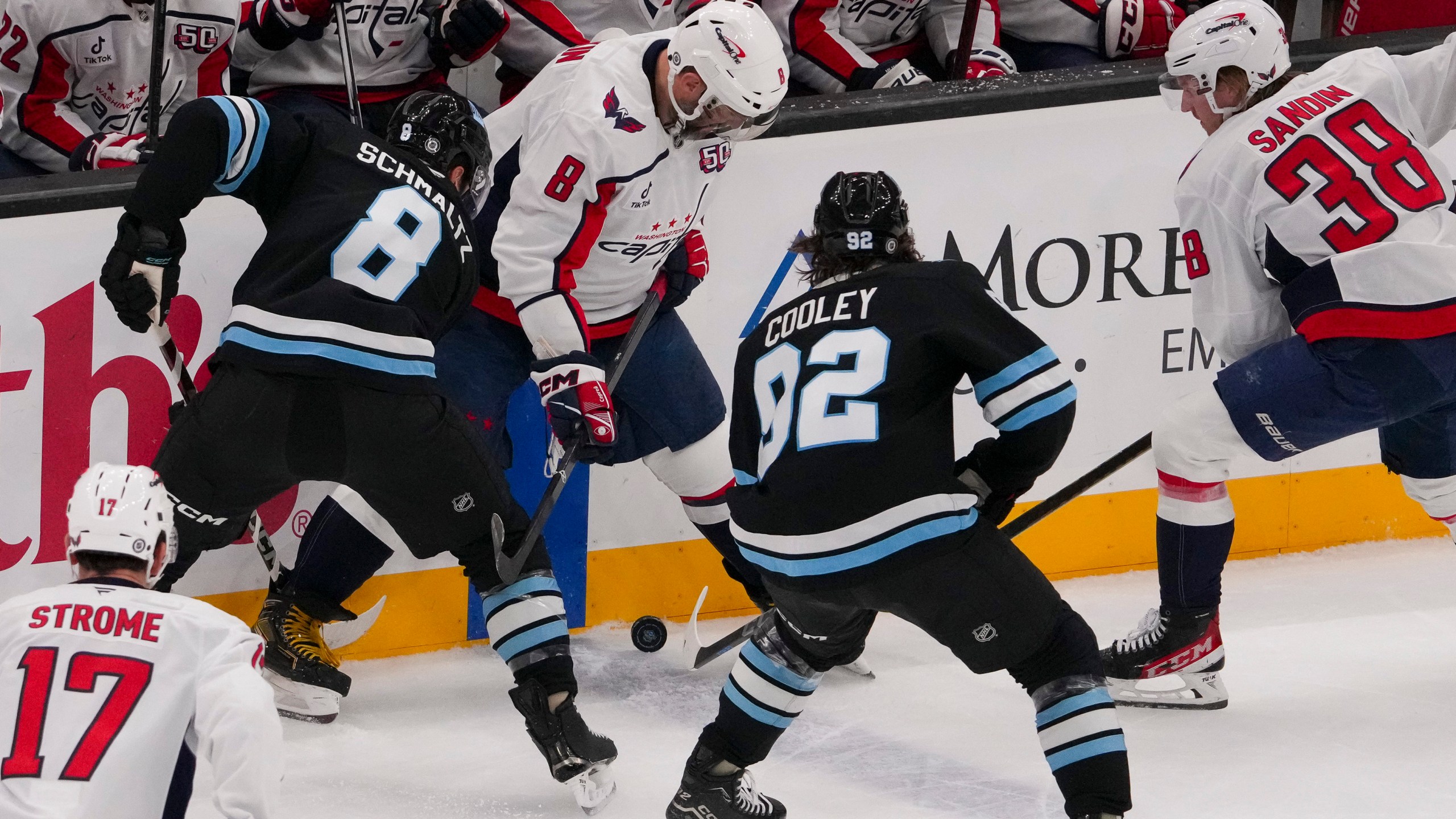 Utah Hockey Club centers Nick Schmaltz (8) and Logan Cooley (92) vie for the puck with Washington Capitals left wing Alex Ovechkin (8) as Capitals defenseman Rasmus Sandin (38) and center Dylan Strome (17) look on during the first period of an NHL hockey game Monday, Nov. 18, 2024, in Salt Lake City. (AP Photo/Bethany Baker)